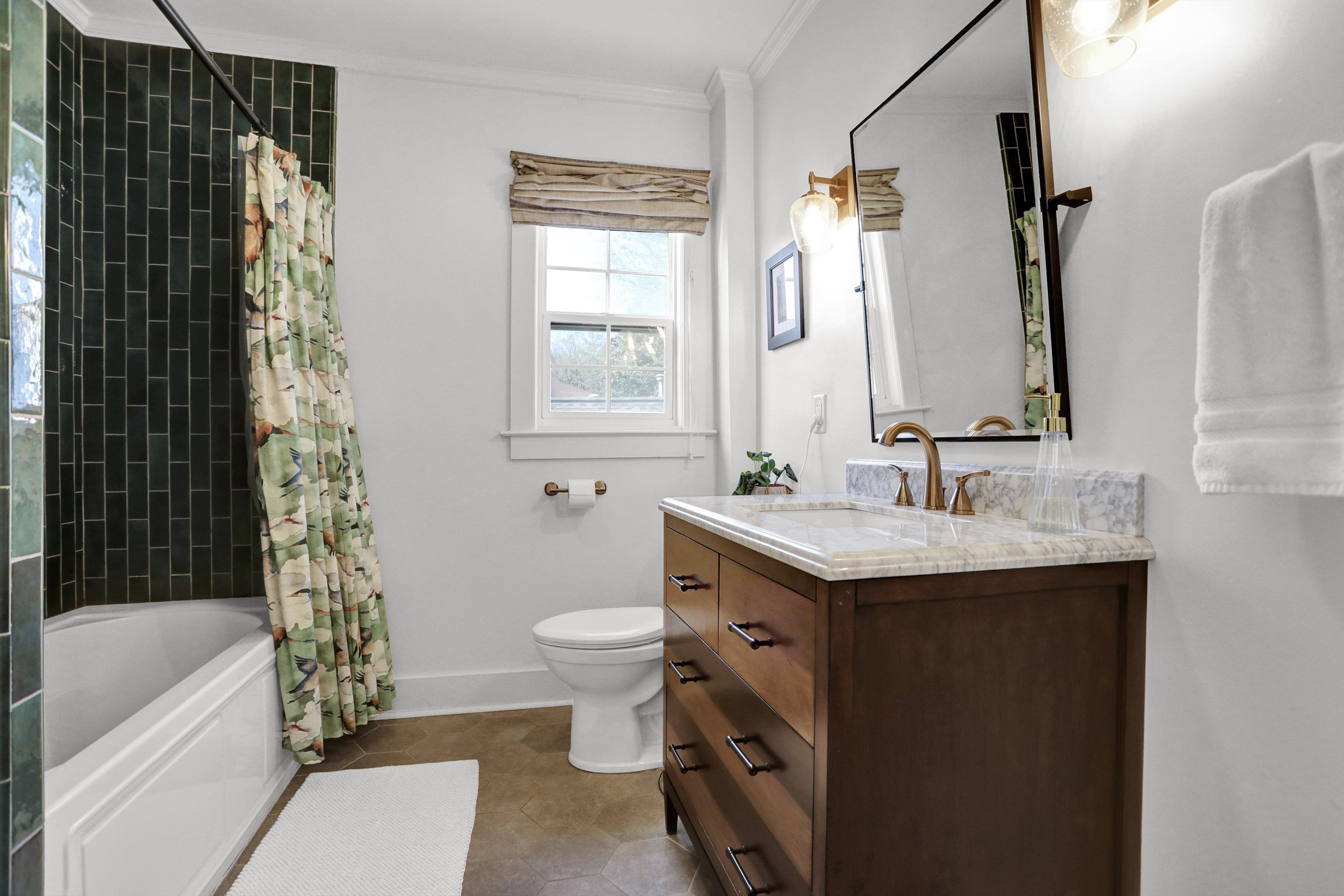 Full bathroom with vanity, toilet, shower / bathtub combination with curtain, and crown molding
