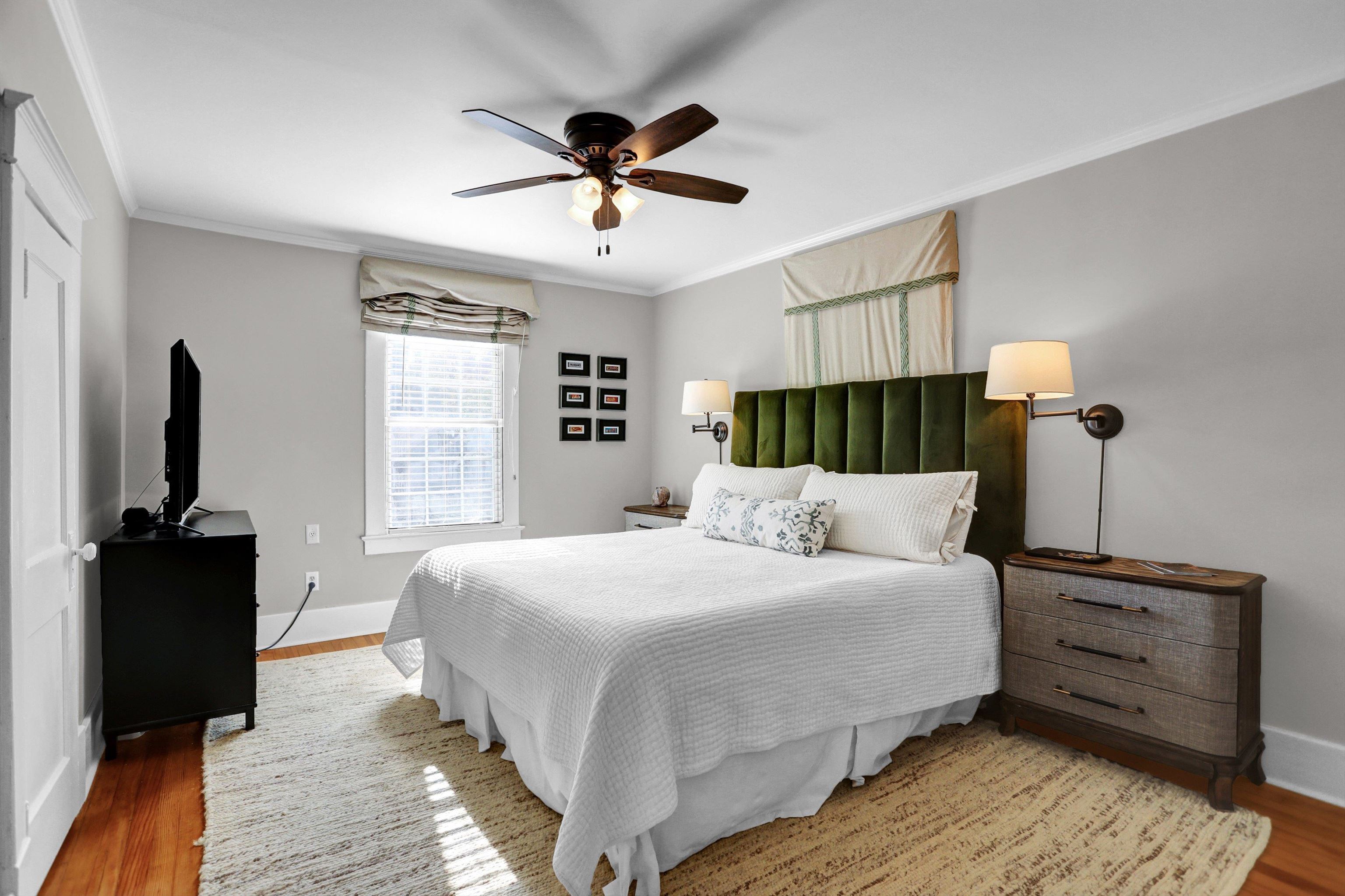 Bedroom with ceiling fan, crown molding, and hardwood / wood-style flooring