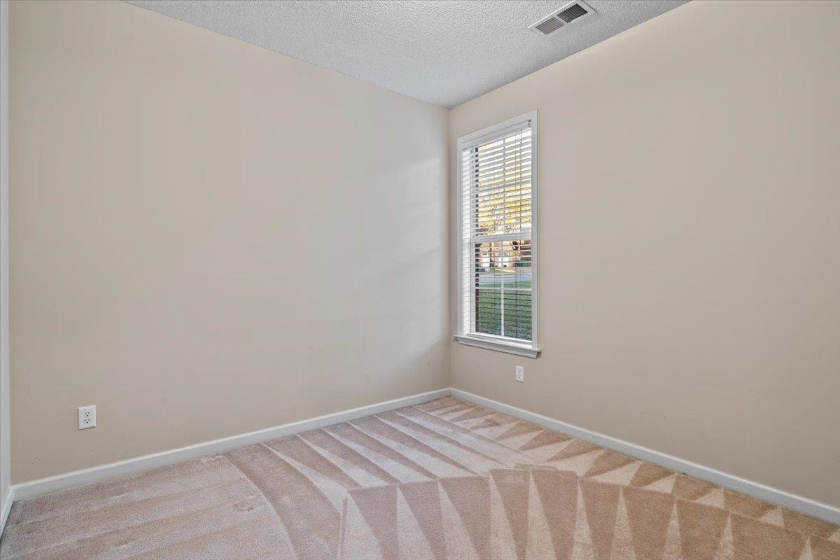 Carpeted spare room with a textured ceiling