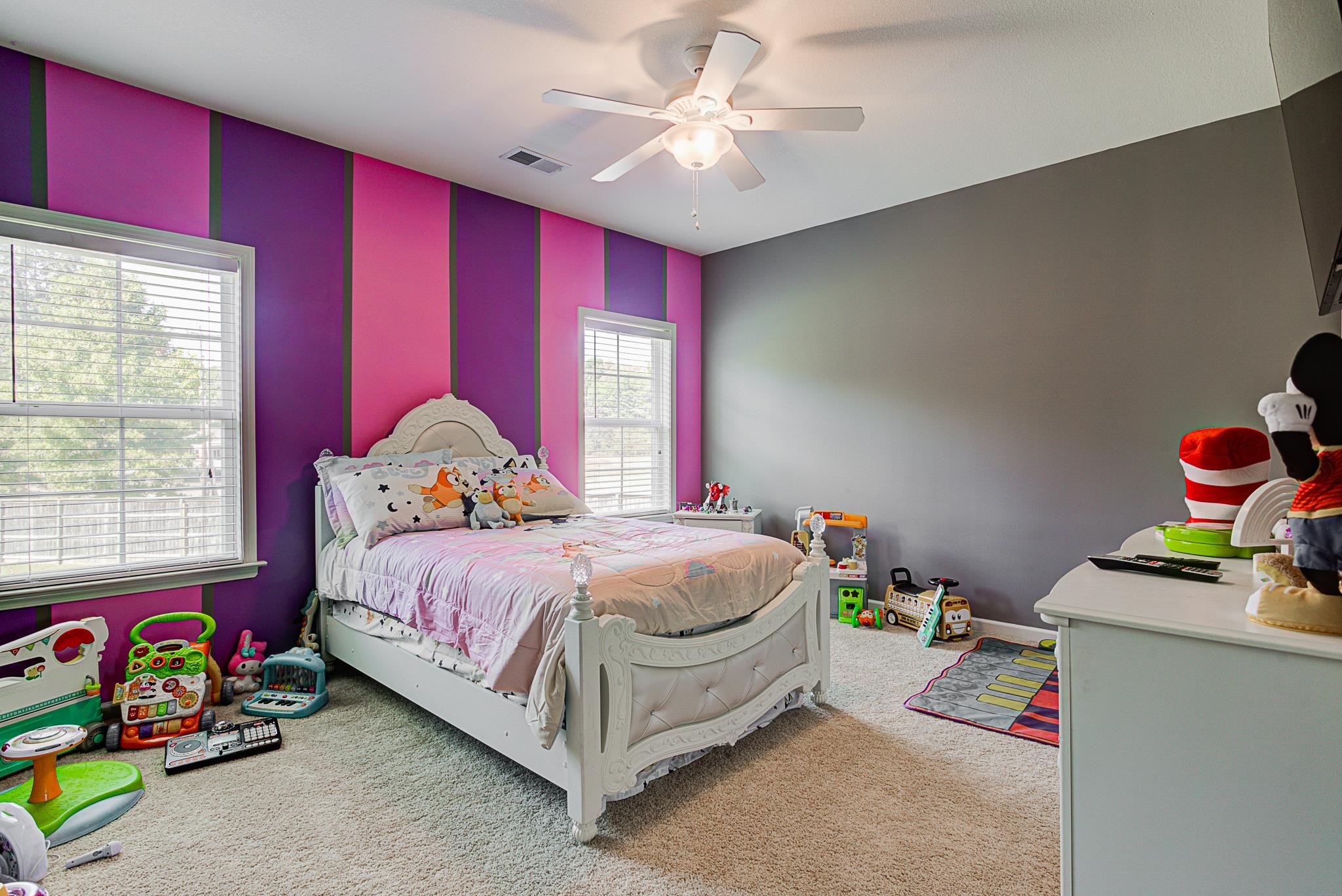 Bedroom with multiple windows, carpet, and ceiling fan