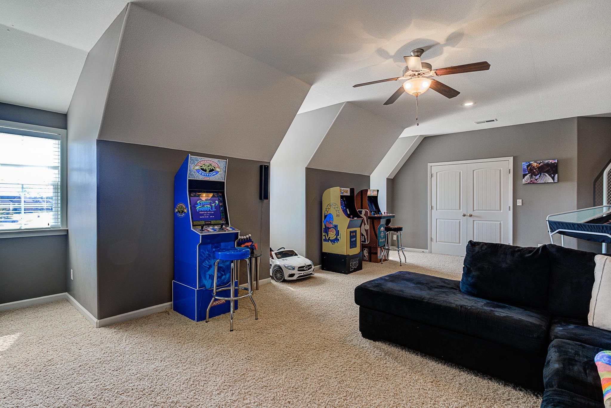 Interior space featuring vaulted ceiling, carpet, and ceiling fan