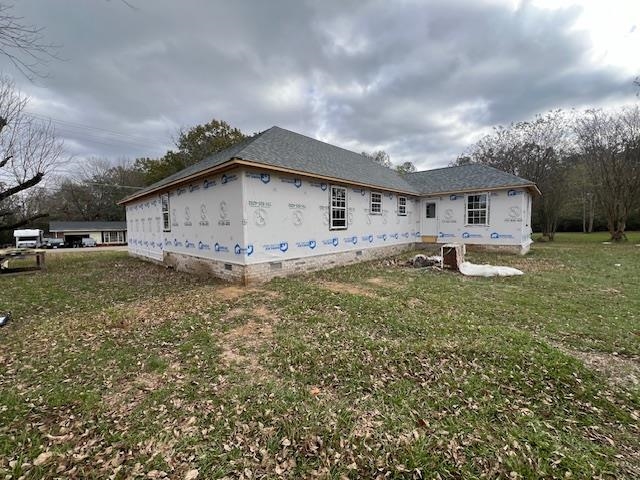 View of side of property featuring a lawn