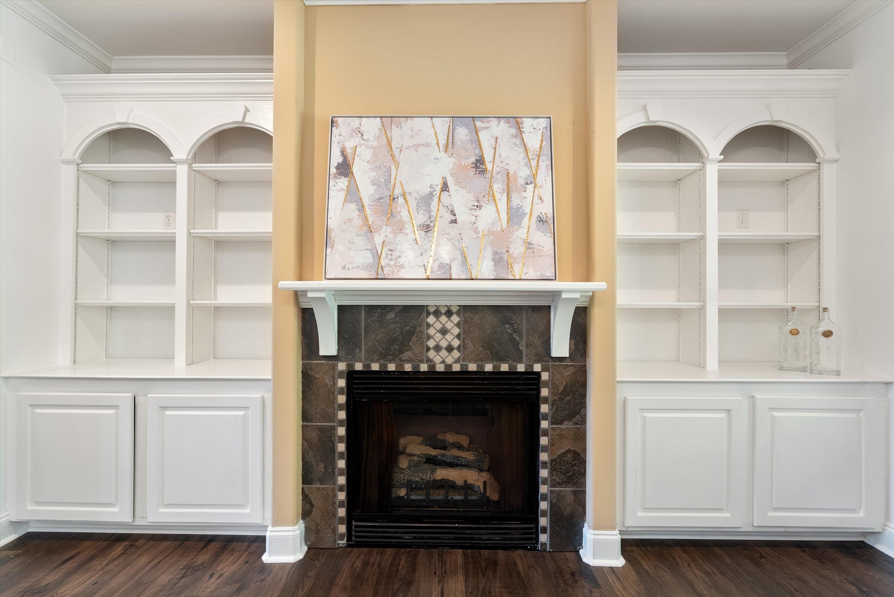 Unfurnished living room featuring a fireplace, ornamental molding, and dark wood-type flooring