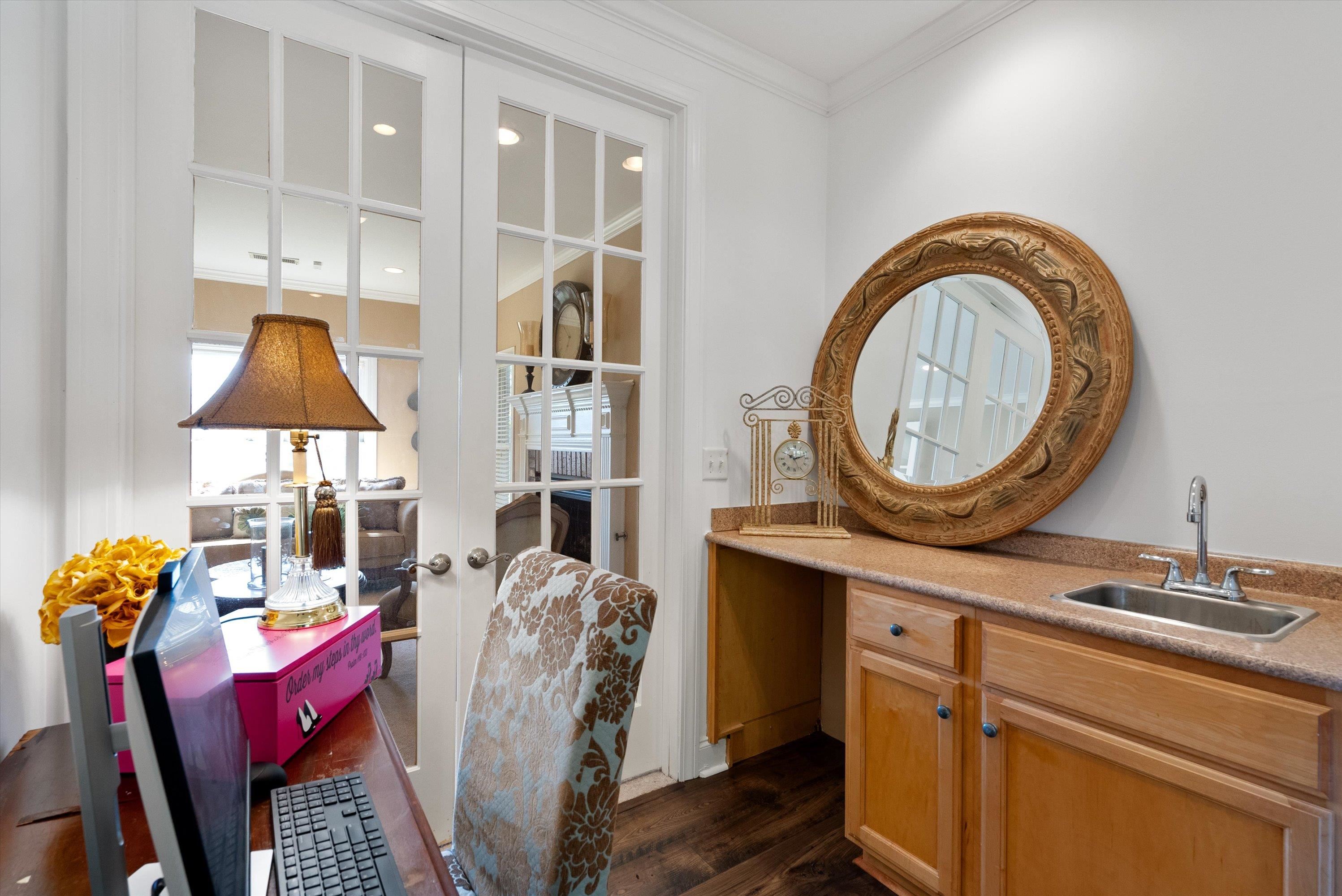 Office with dark hardwood / wood-style flooring, ornamental molding, and sink