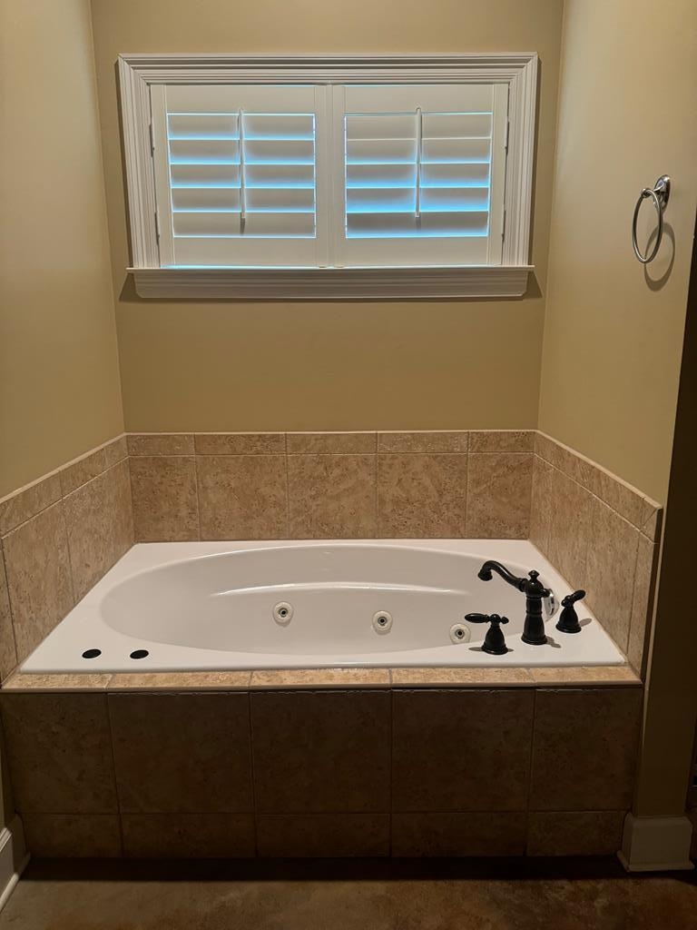 Bathroom featuring a healthy amount of sunlight and tiled bath