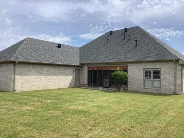 Rear view of property with a lawn