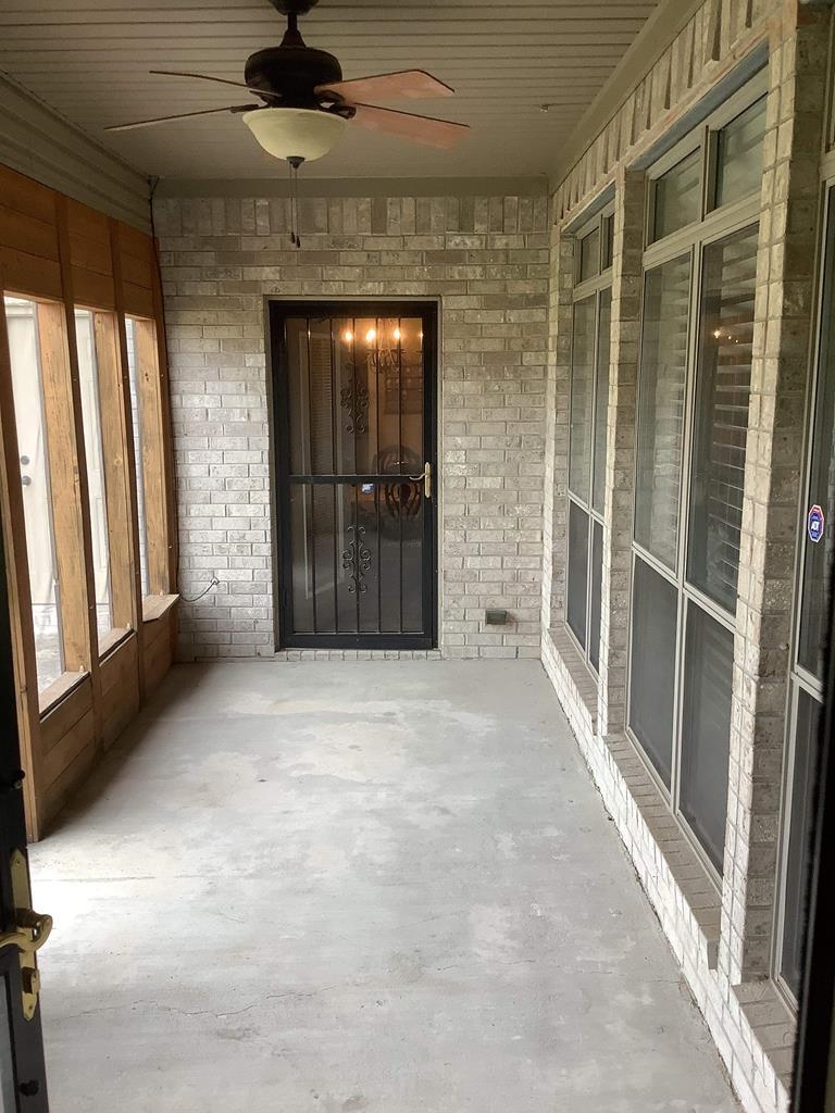Unfurnished sunroom featuring ceiling fan
