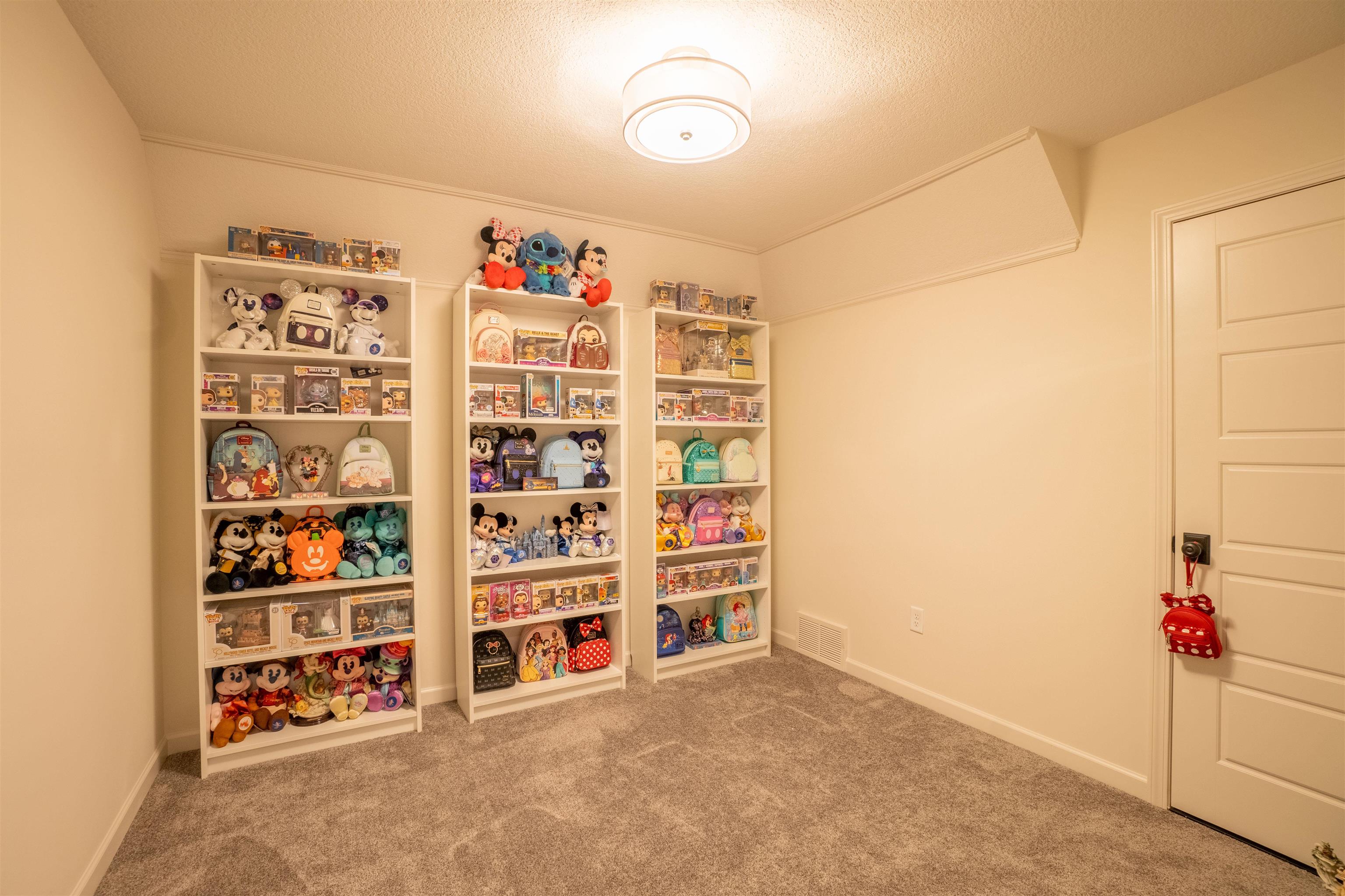 Rec room featuring carpet floors, a textured ceiling, and ornamental molding