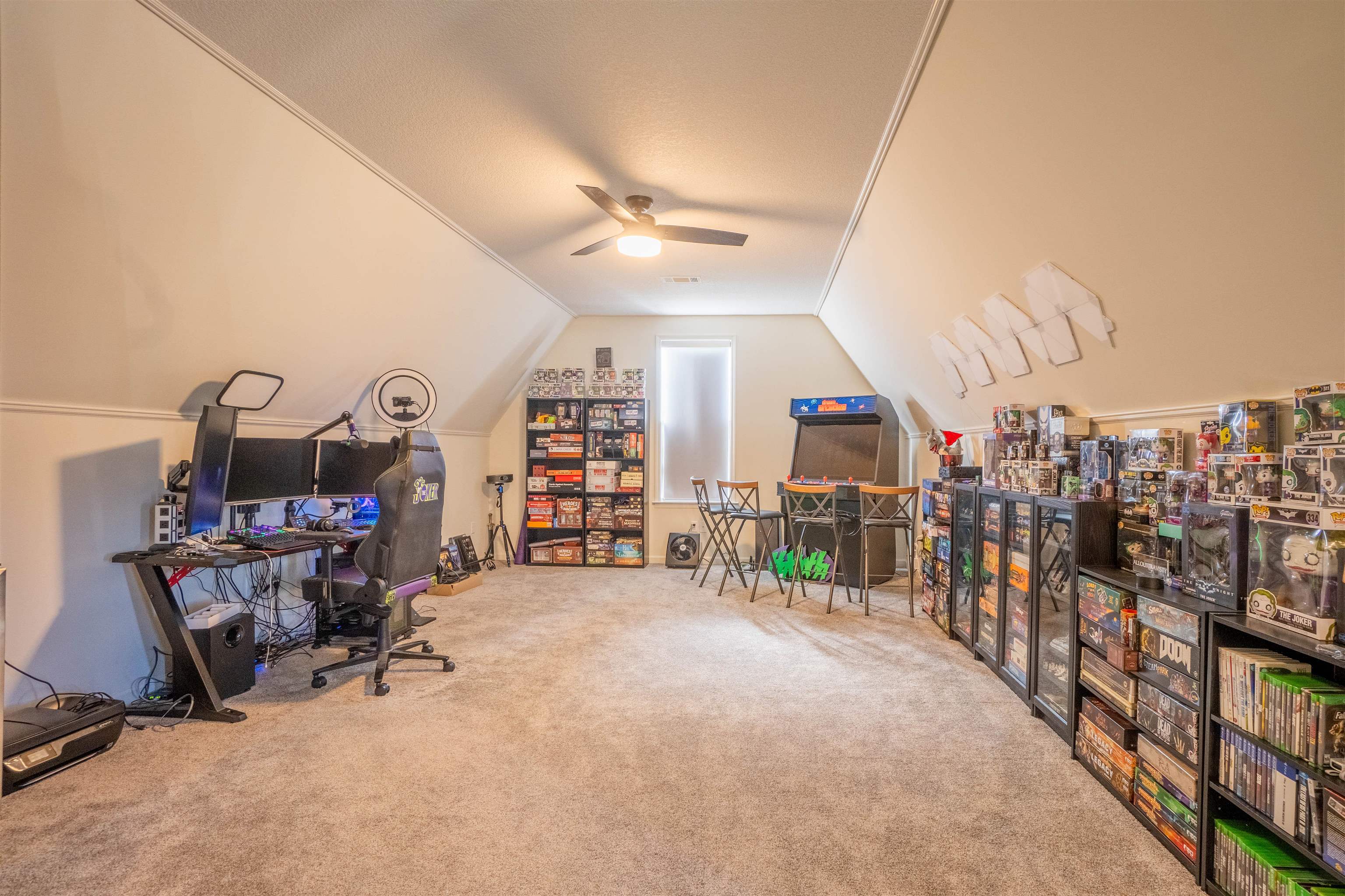 Office area with ceiling fan, carpet floors, and vaulted ceiling