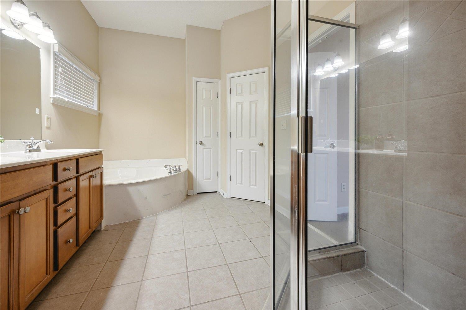 Bathroom with tile patterned floors, vanity, and independent shower and bath