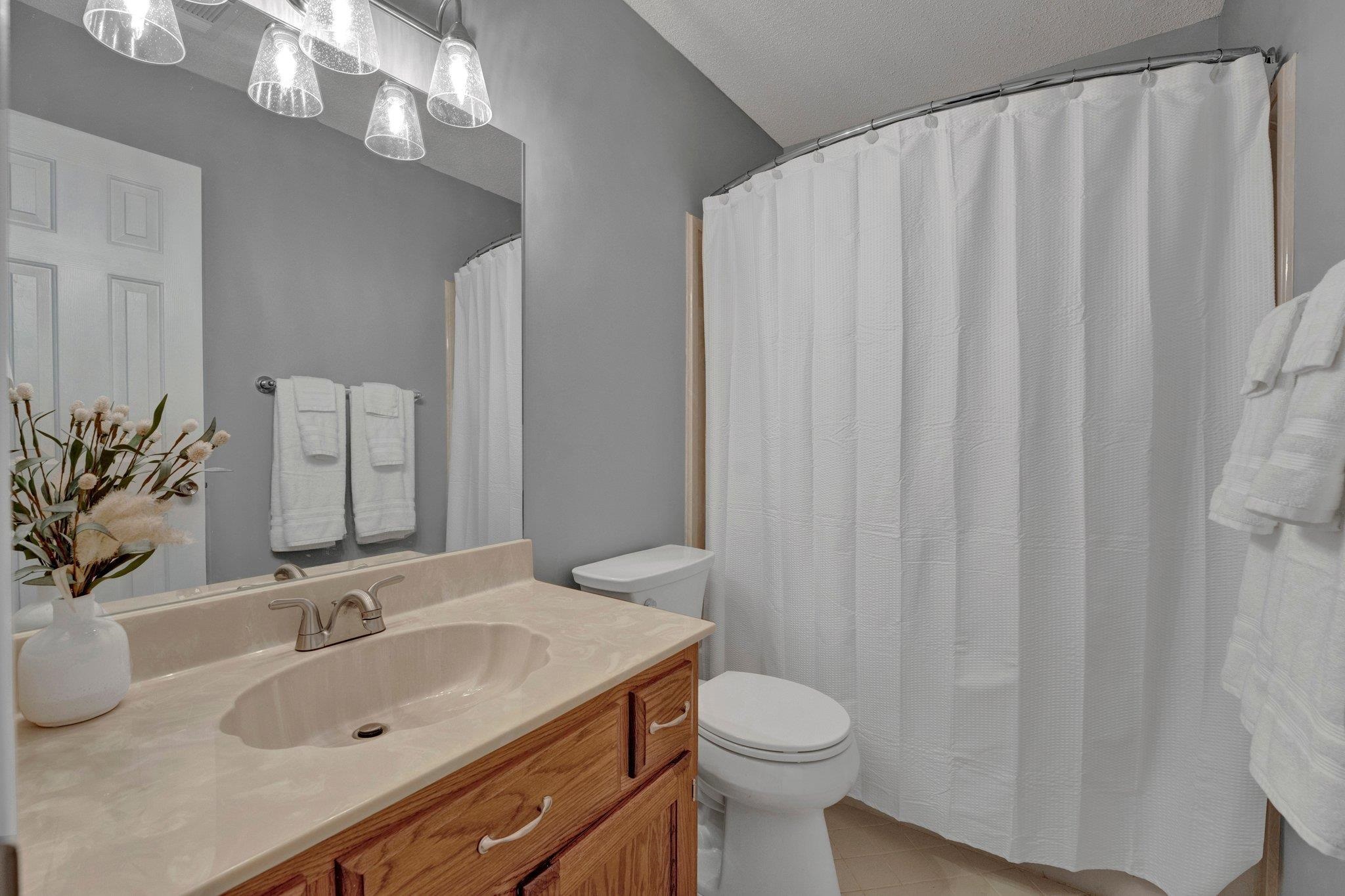 Bathroom with tile patterned floors, vanity, toilet, and a textured ceiling