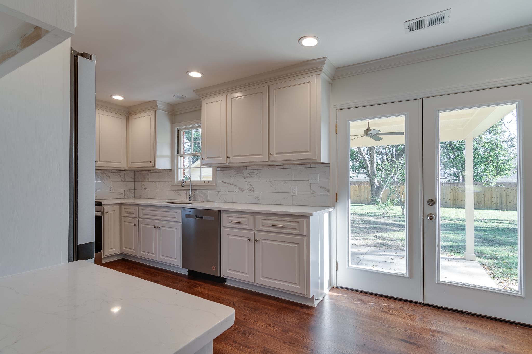 Kitchen with white cabinets, plenty of natural light, and stainless steel dishwasher