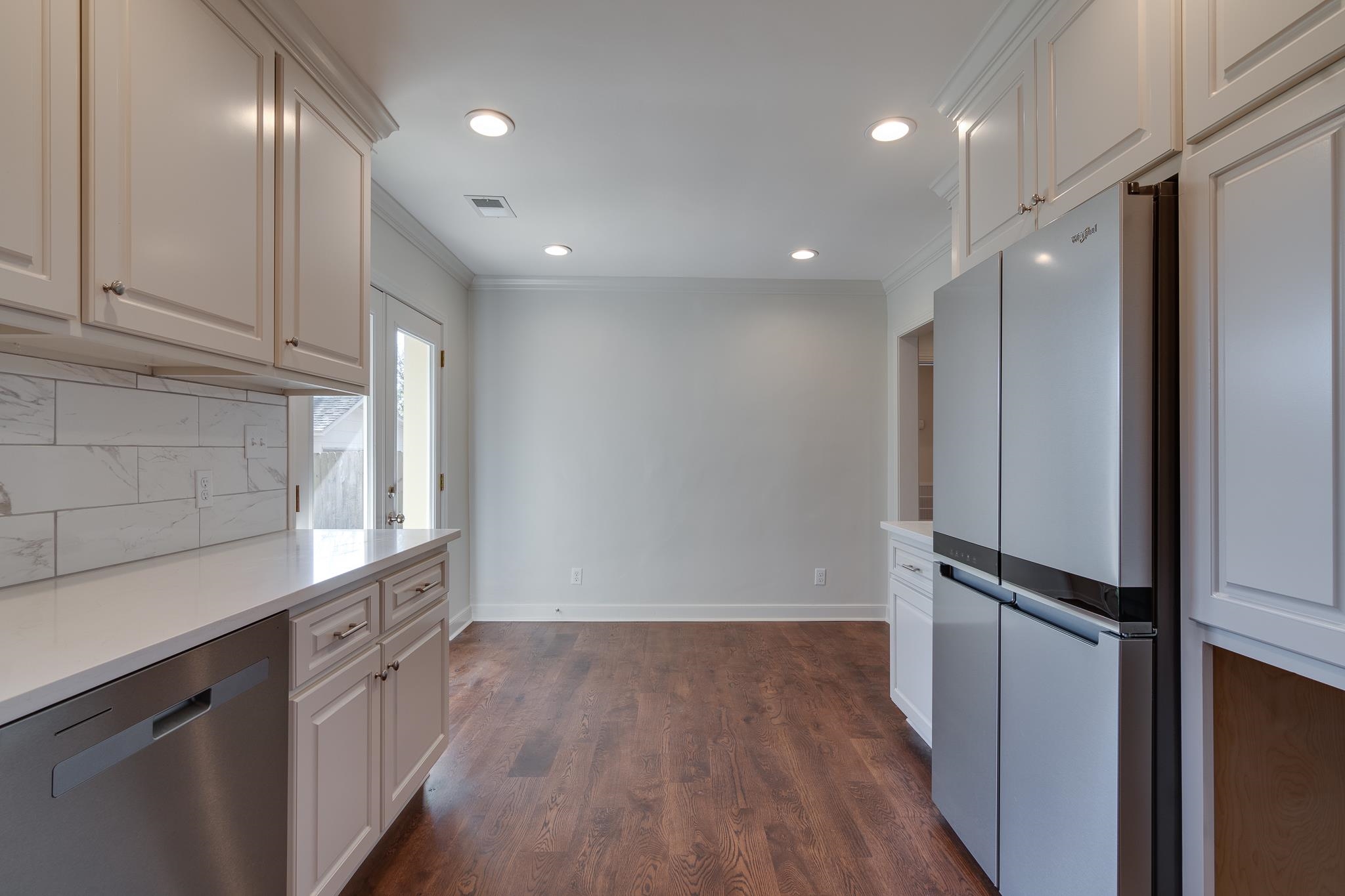 Kitchen with appliances with stainless steel finishes, white cabinetry, and ornamental molding