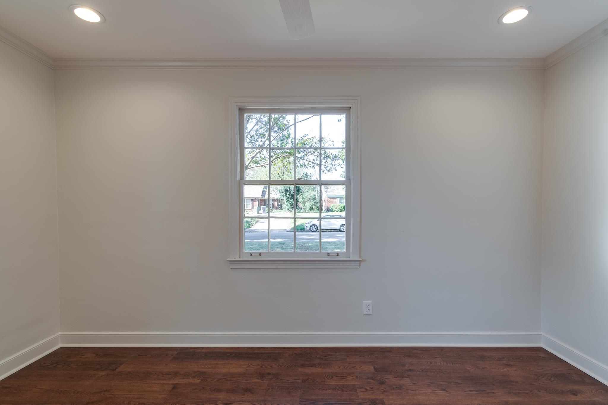 Spare room featuring dark hardwood / wood-style floors and crown molding