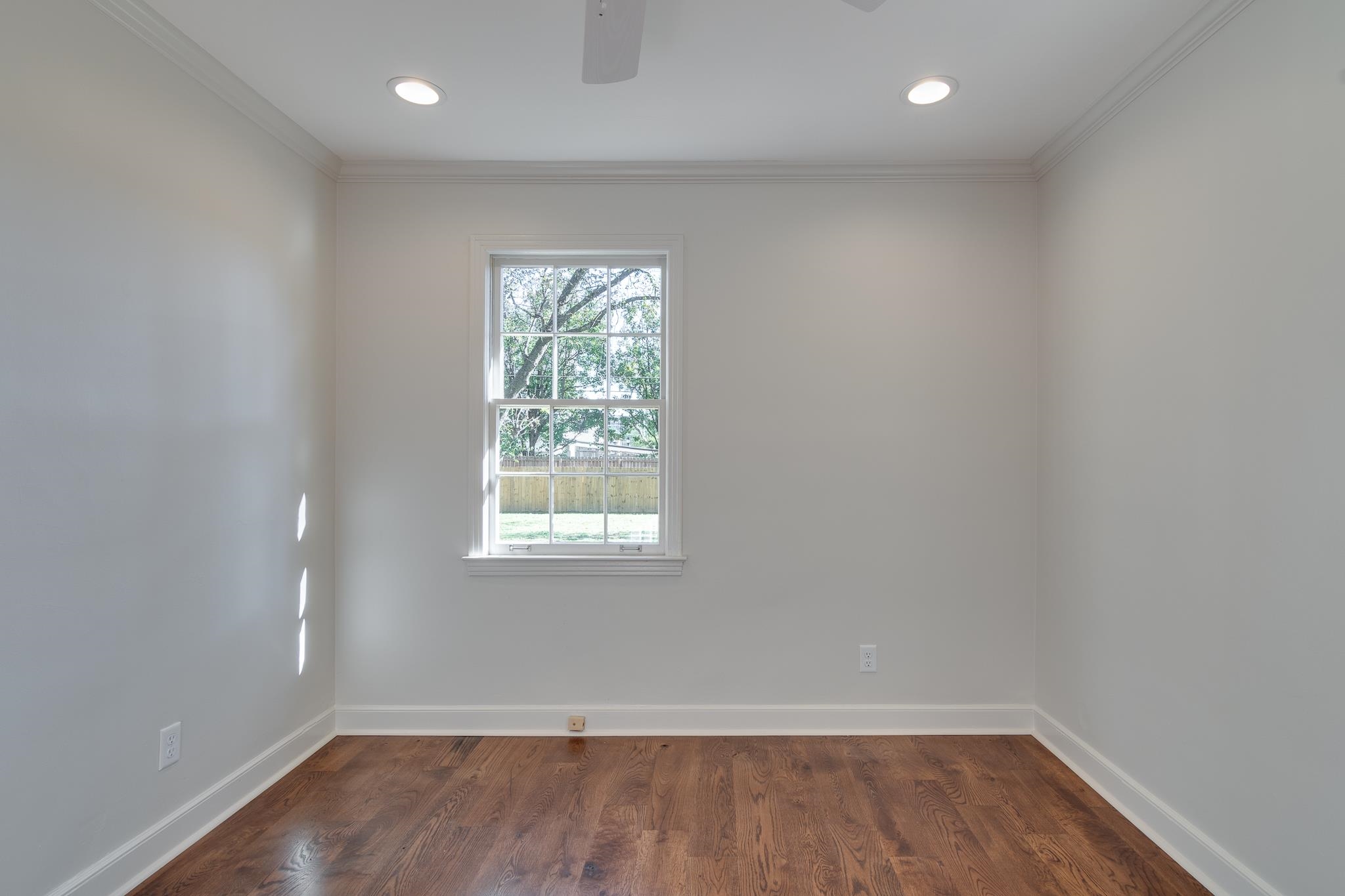 Empty room featuring crown molding and dark hardwood / wood-style floors