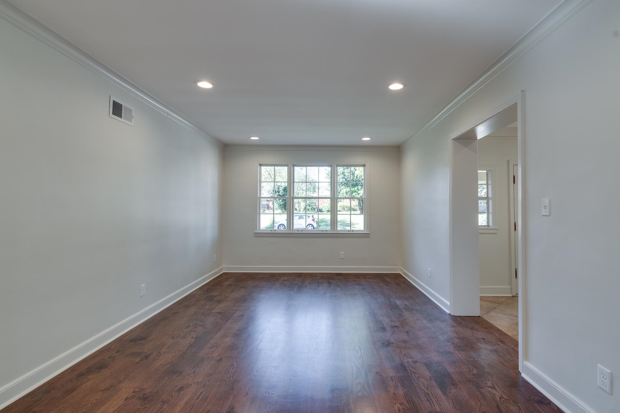 Spare room with dark hardwood / wood-style flooring and ornamental molding