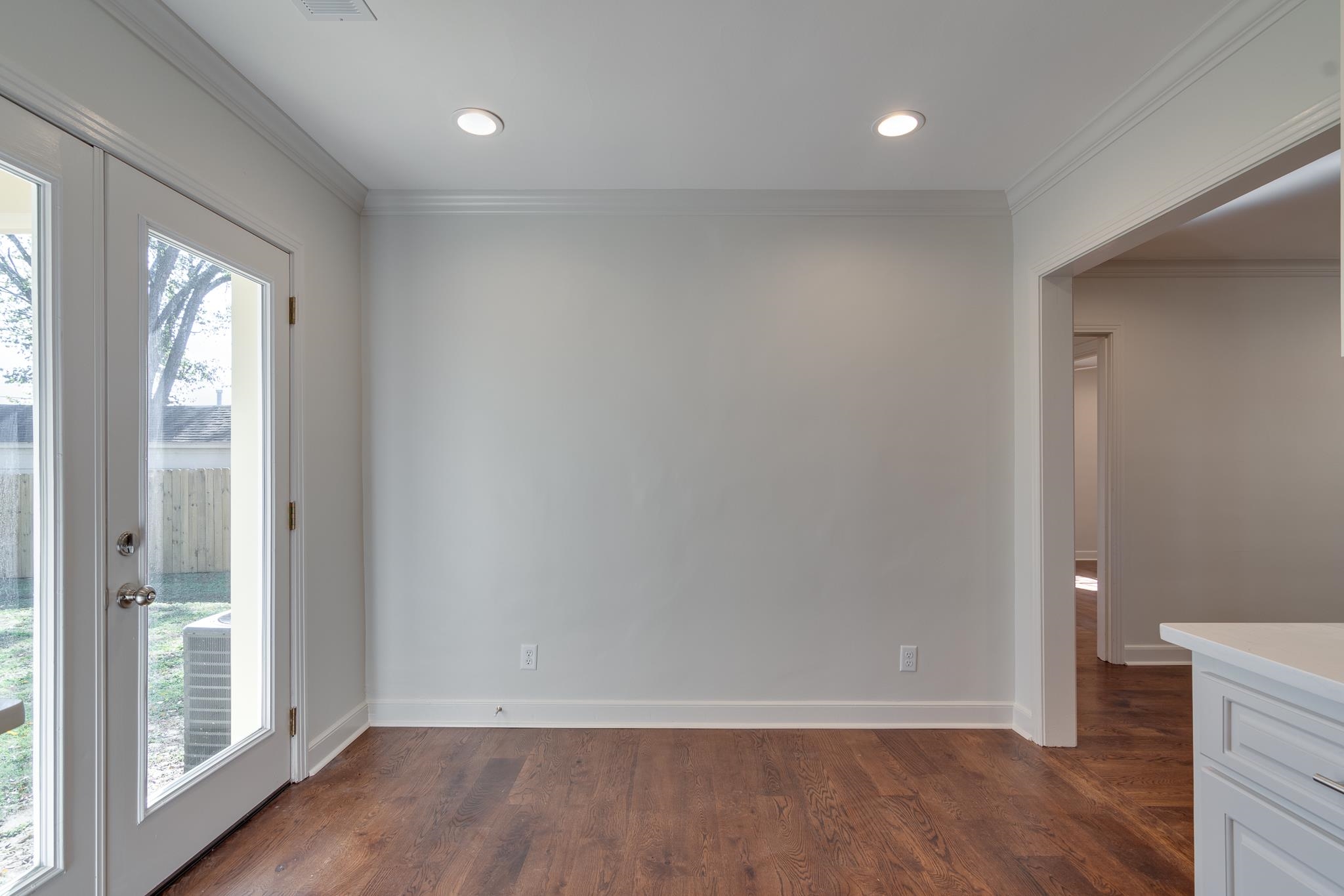 Unfurnished dining area with dark hardwood / wood-style flooring and ornamental molding