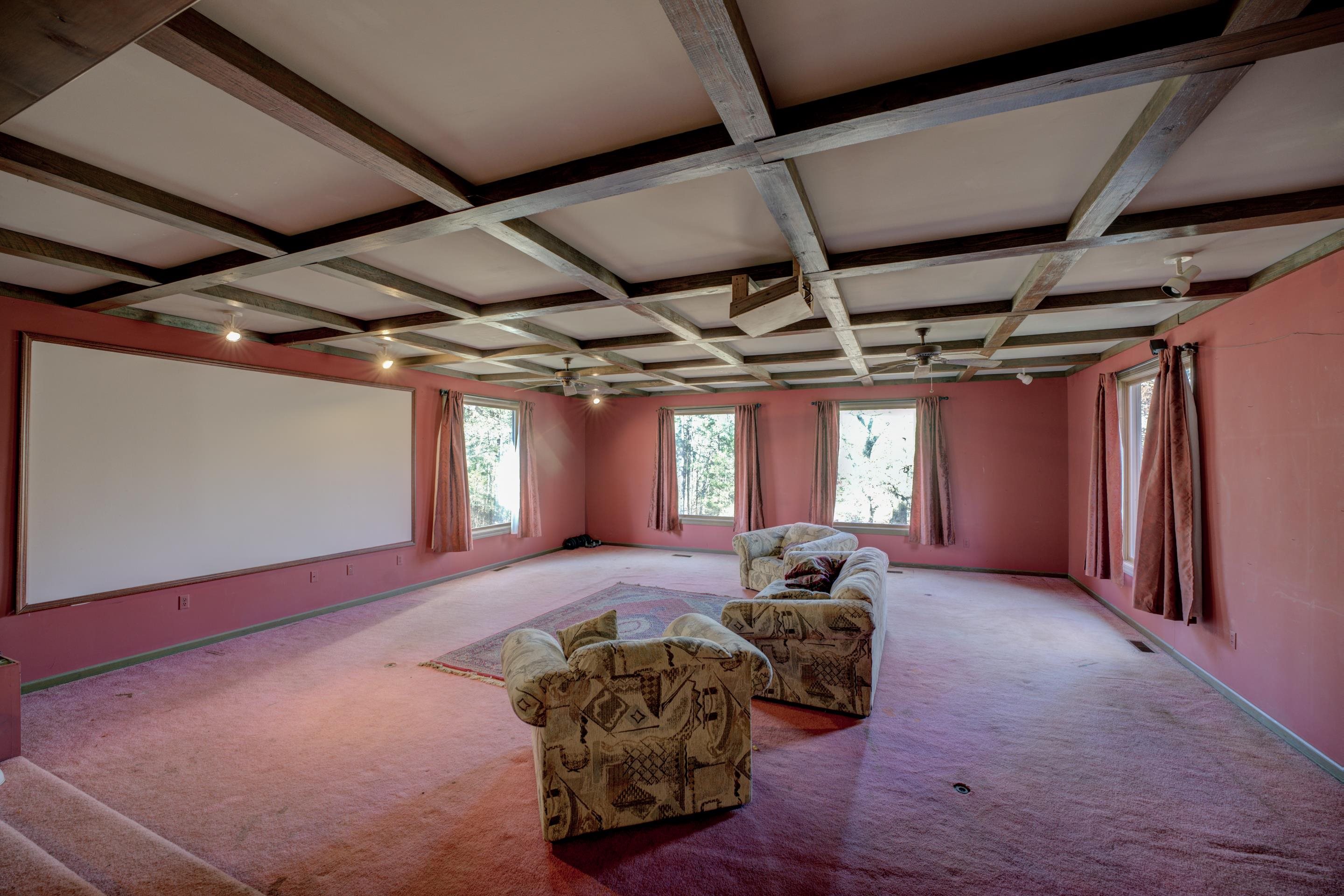 Unfurnished room with beam ceiling, light colored carpet, and coffered ceiling