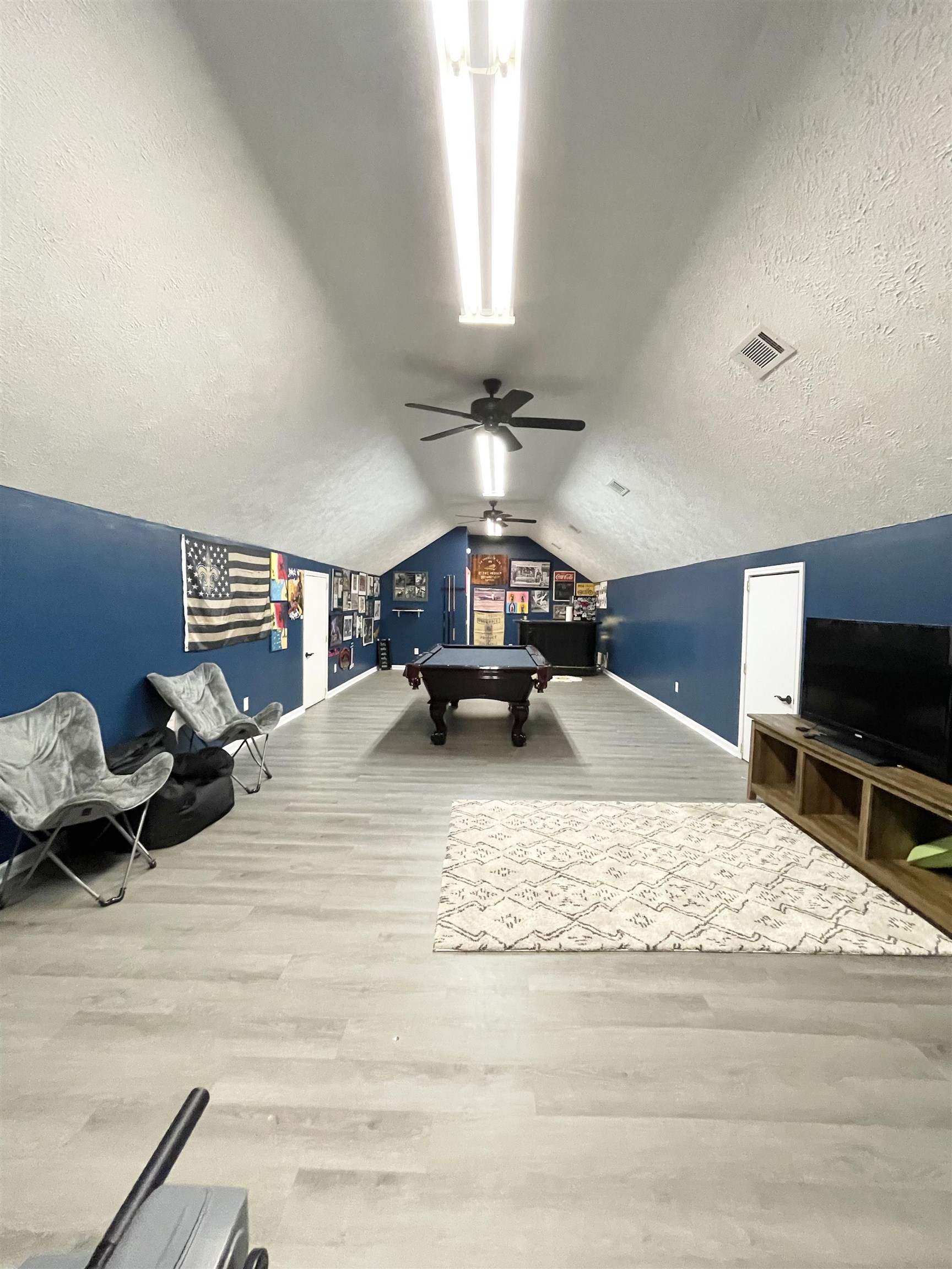 Recreation room with ceiling fan, wood-type flooring, a textured ceiling, vaulted ceiling, and pool table