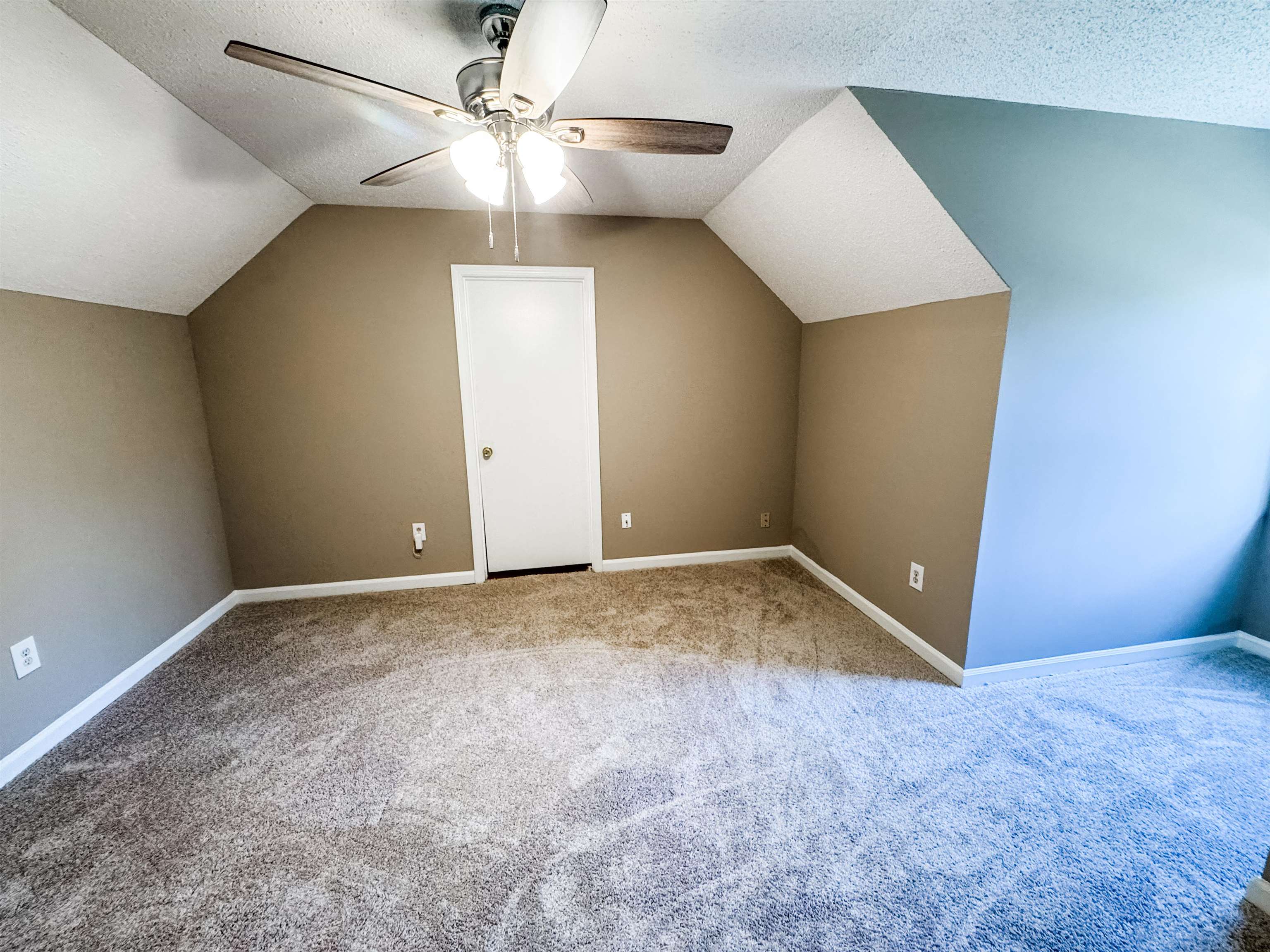 Additional living space with carpet flooring, ceiling fan, a textured ceiling, and vaulted ceiling