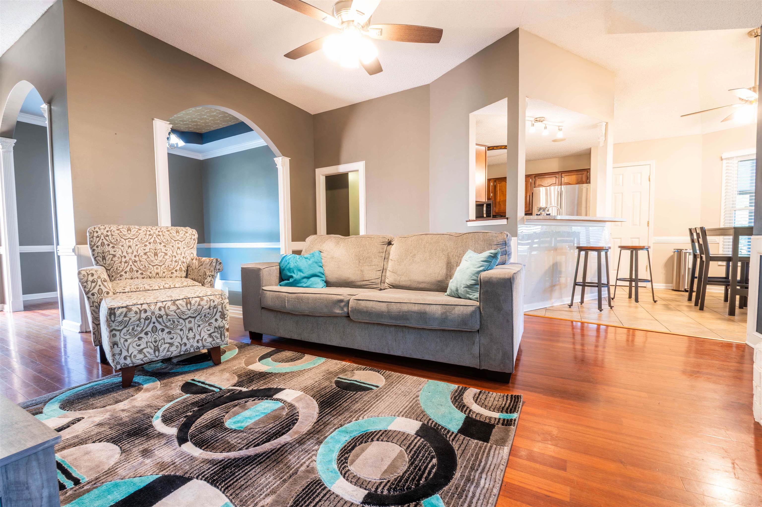 Living room with ceiling fan, light hardwood / wood-style flooring, and crown molding