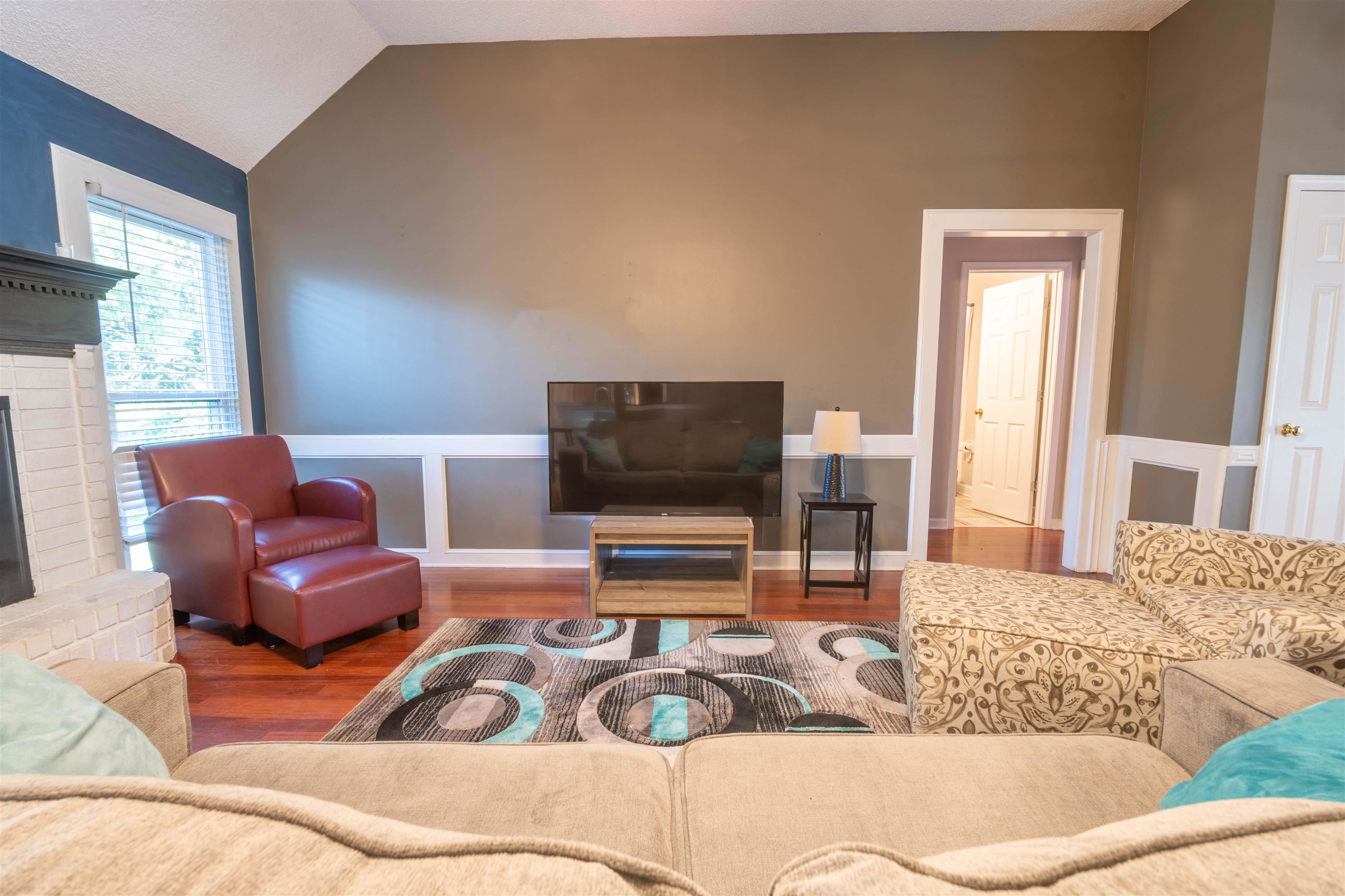 Living room featuring lofted ceiling, wood-type flooring, and a fireplace