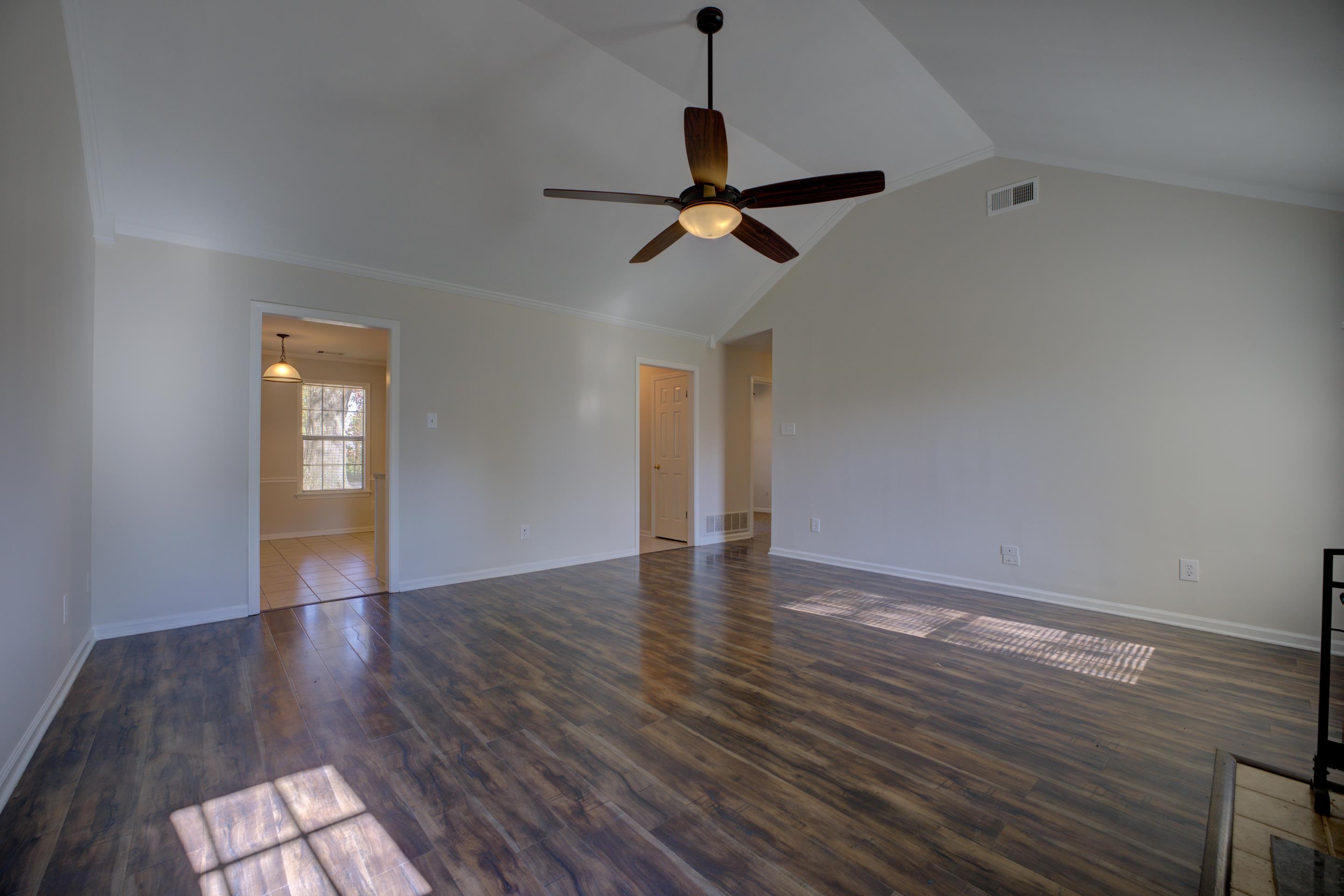 Empty room featuring ceiling fan, dark wood-type flooring, and vaulted ceiling