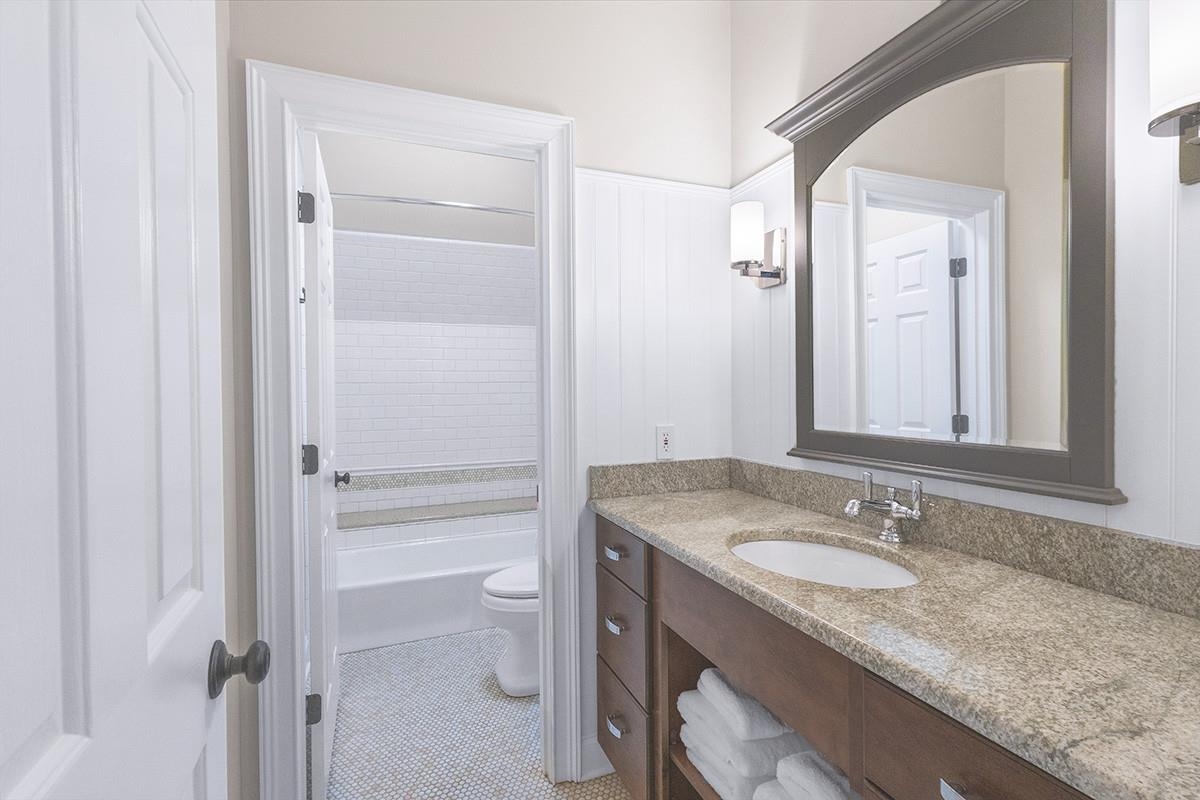 Full bathroom featuring tile patterned flooring, vanity, toilet, and tiled shower / bath