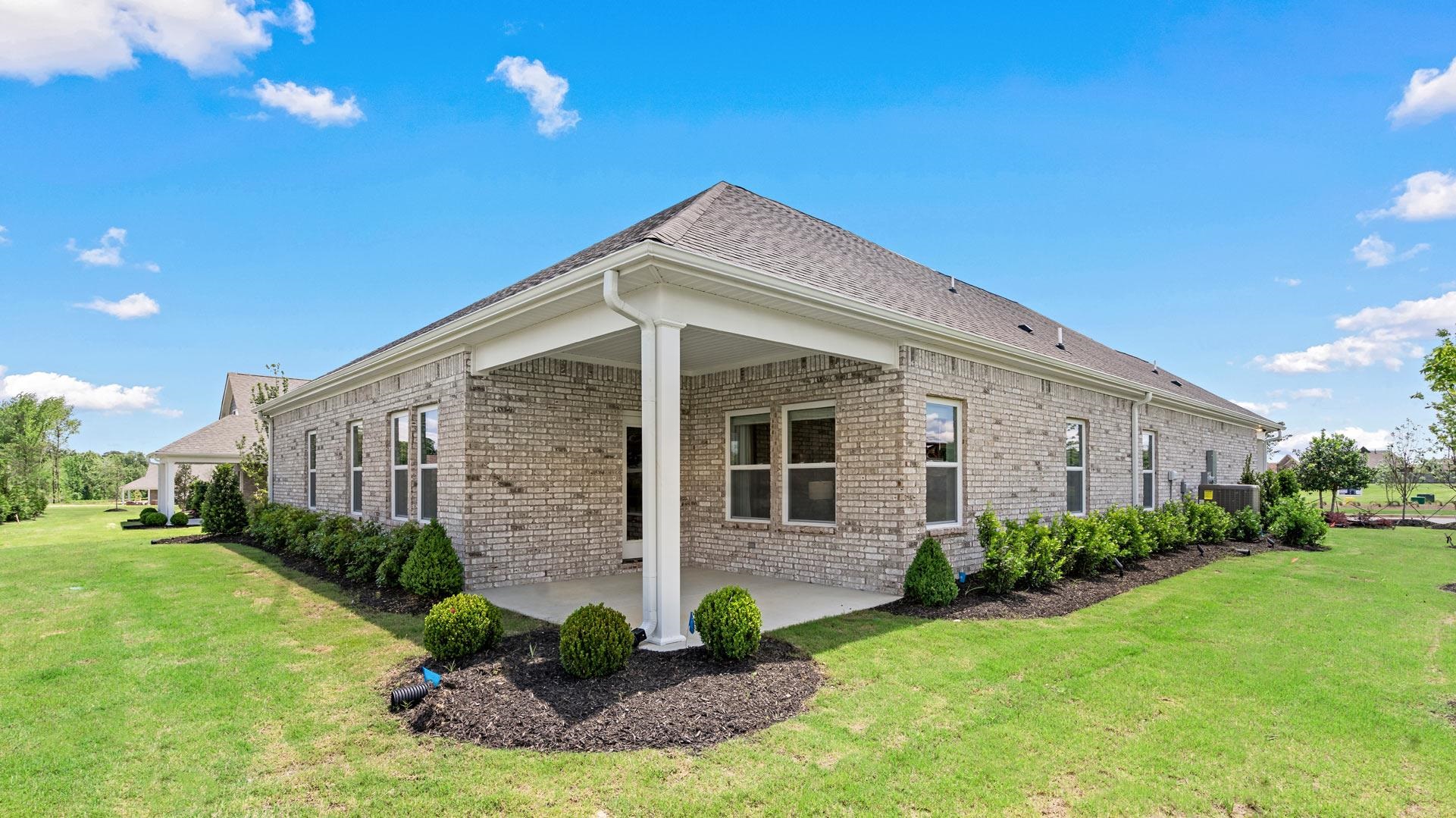 View of property exterior with a lawn and a patio