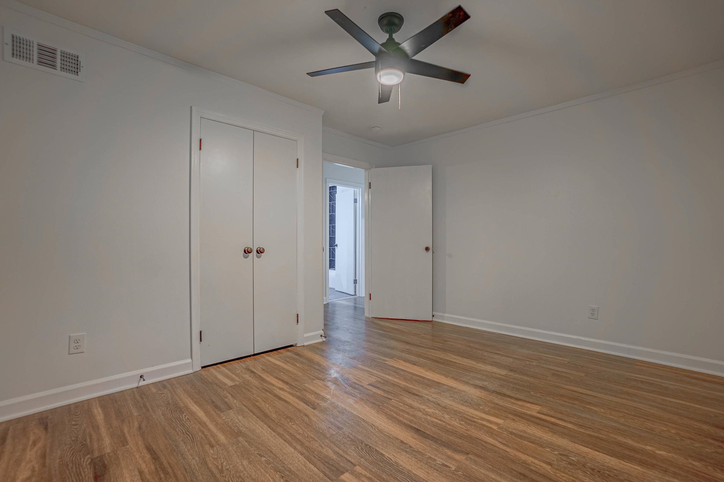 Unfurnished bedroom featuring a closet, ceiling fan, crown molding, and light wood-type flooring