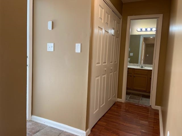 Hallway with light wood-type flooring and sink