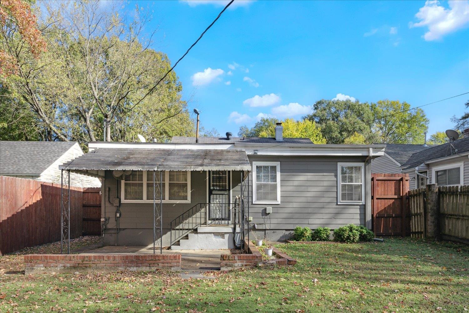 Rear view of property with a lawn