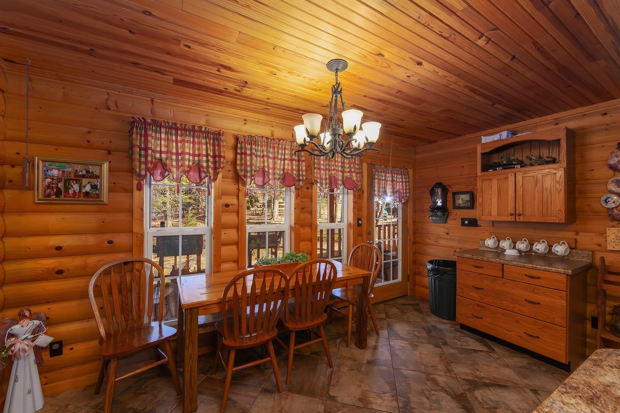 Dining space featuring an inviting chandelier and wood ceiling