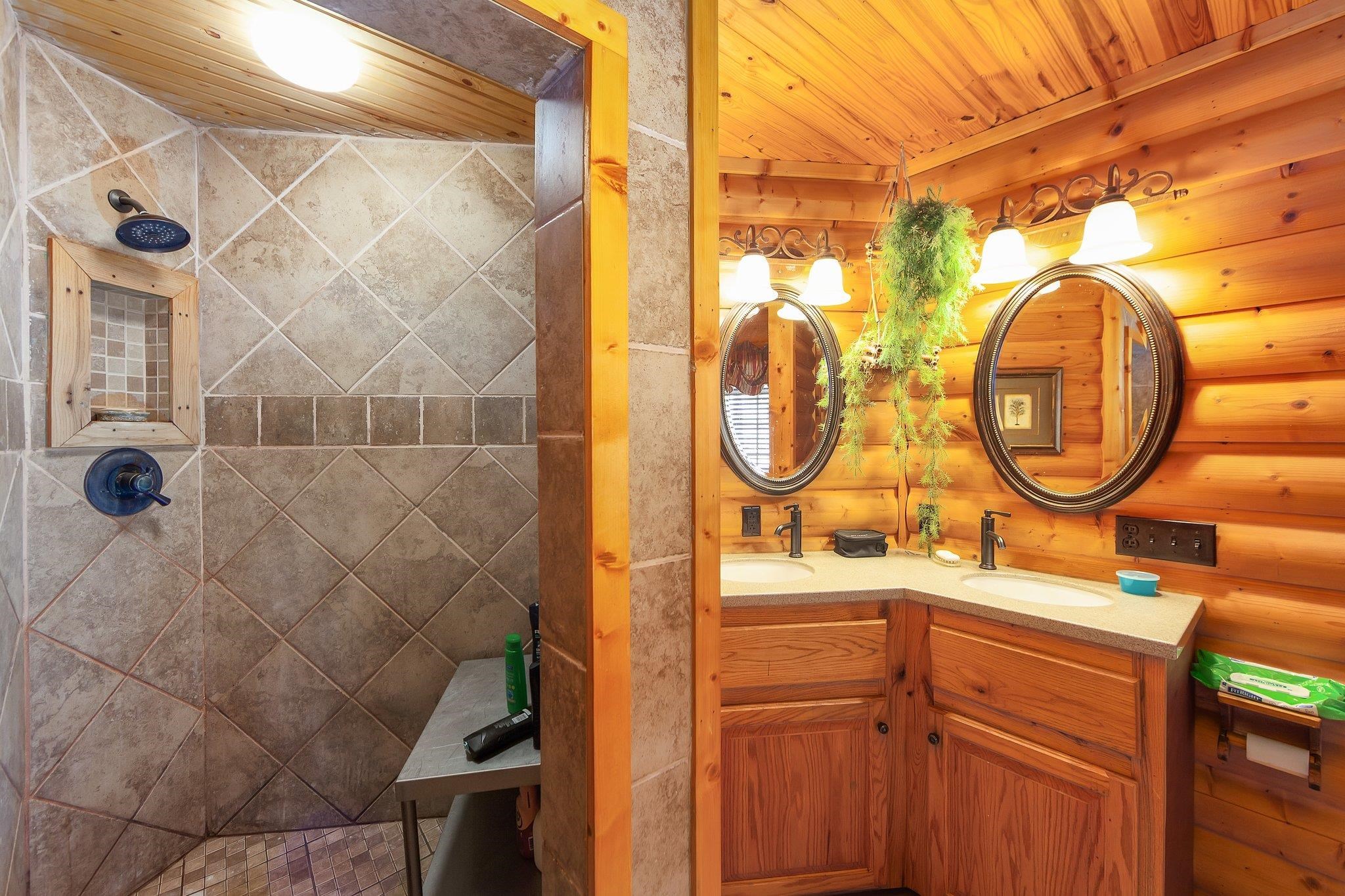 Bathroom with vanity, wood ceiling, and wood walls
