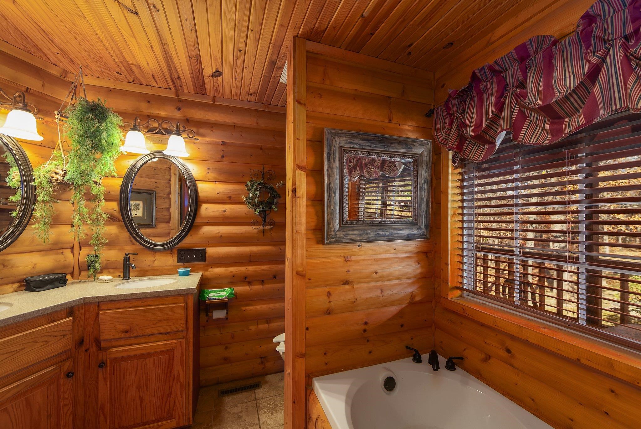 Bathroom with plenty of natural light, wooden ceiling, and a tub to relax in