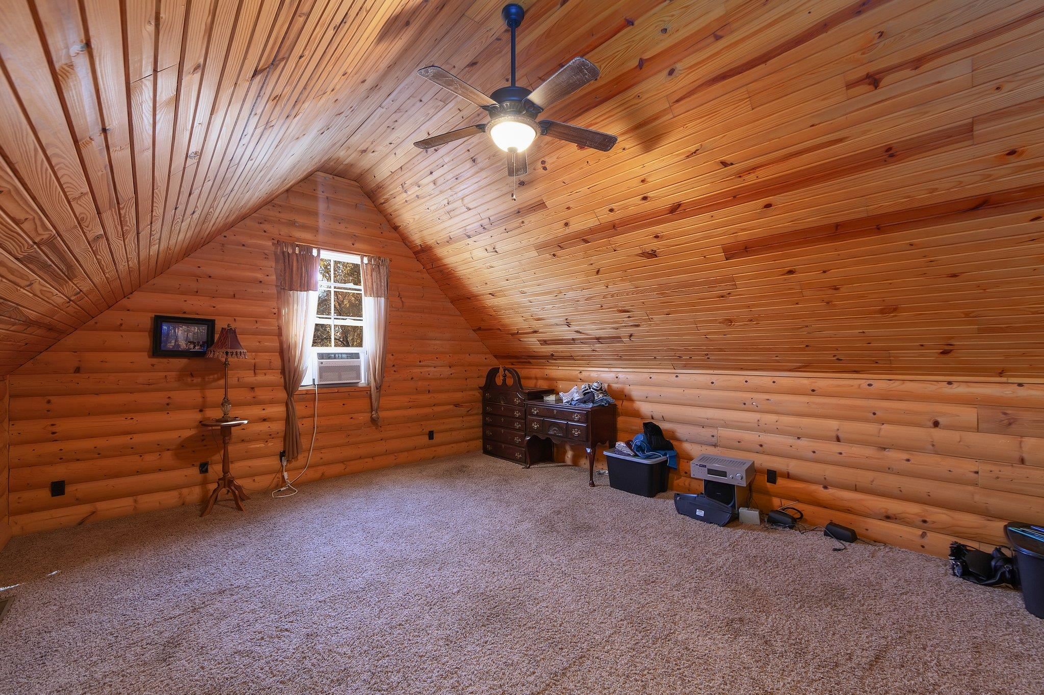 Bonus room with carpet, lofted ceiling, cooling unit, rustic walls, and wood ceiling