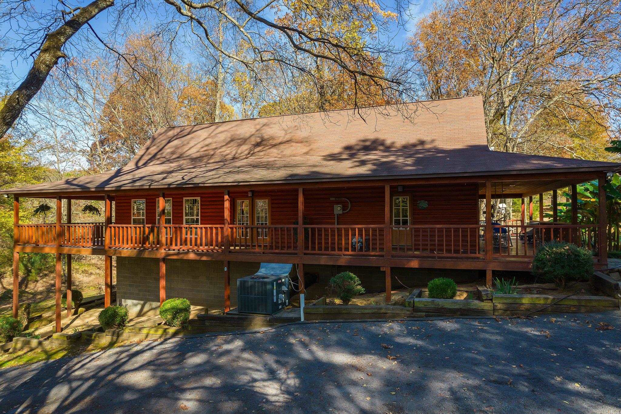 View of front of home with a wooden deck and cooling unit
