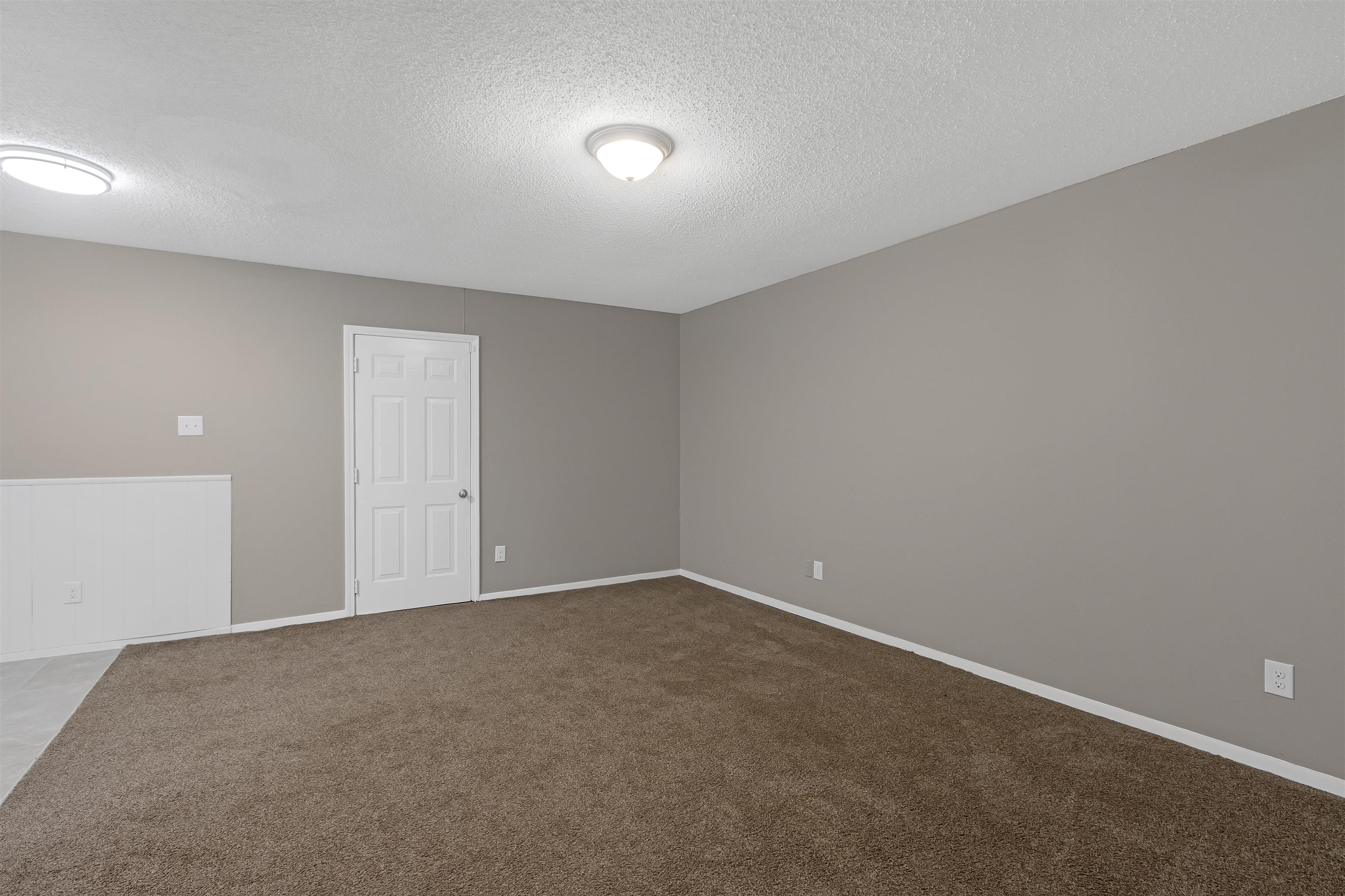 Carpeted spare room with a textured ceiling