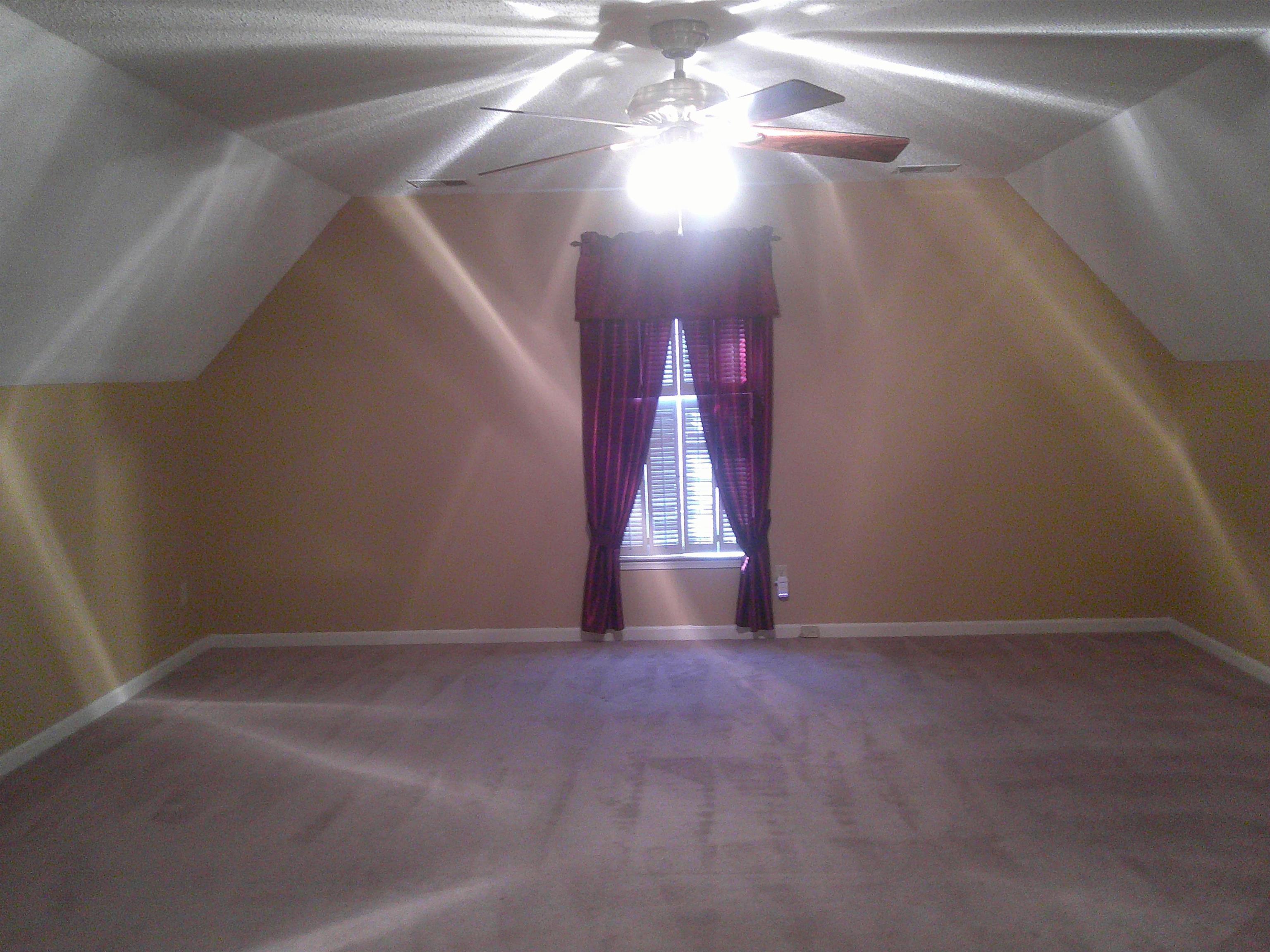 Featuring carpet flooring, ceiling fan, lofted ceiling, and a textured ceiling