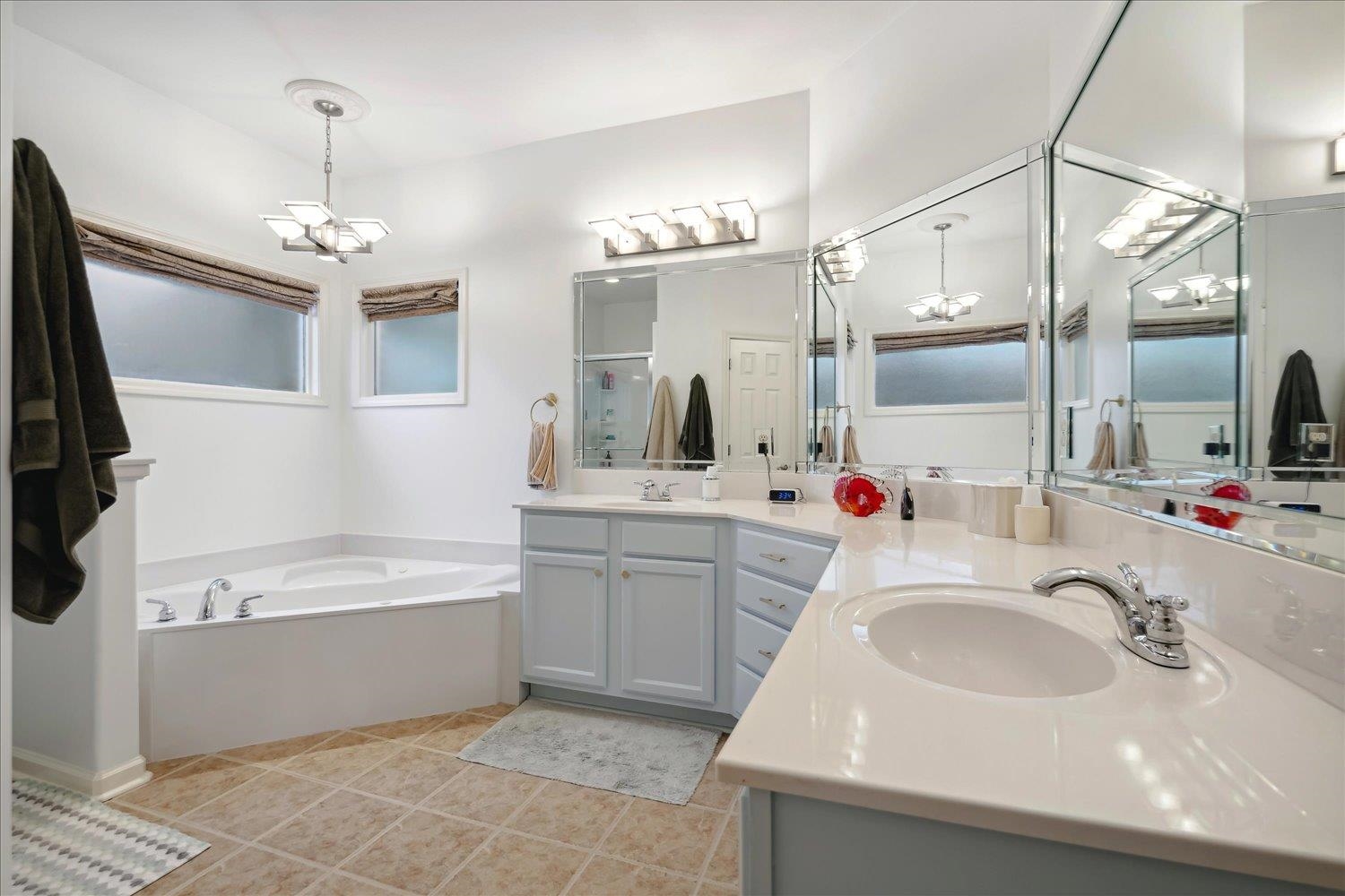 Bathroom featuring walk in shower, vanity, and tile patterned flooring