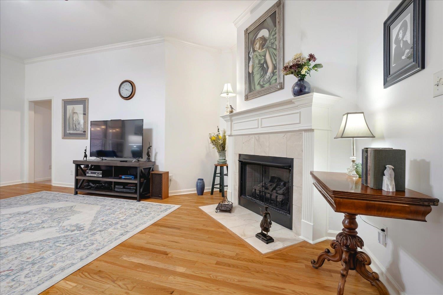 Great Room with a tile fireplace, hardwood / wood-style floors, and crown molding