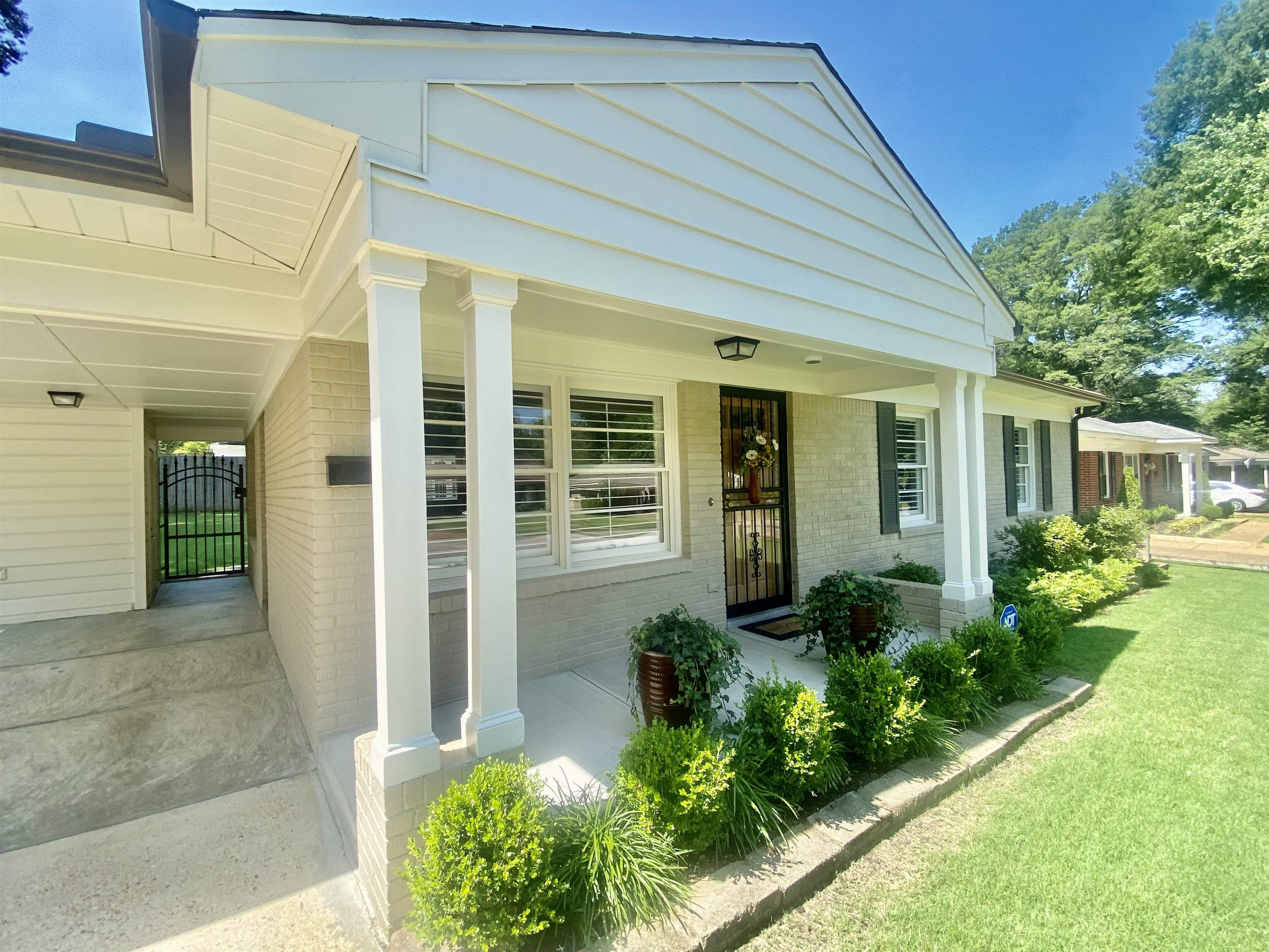 View of front facade with covered porch and a front lawn