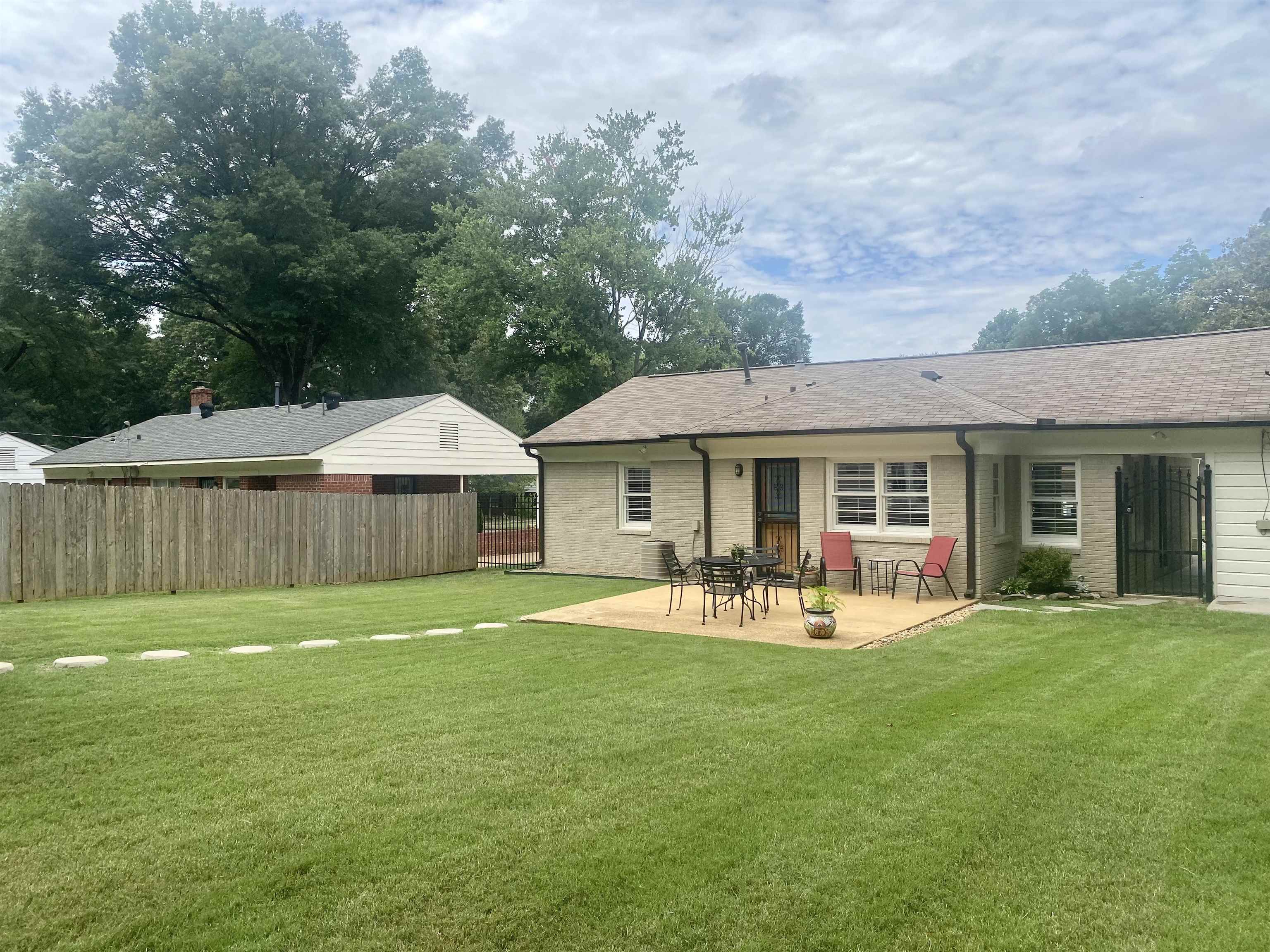 Back of property with a patio and a lawn