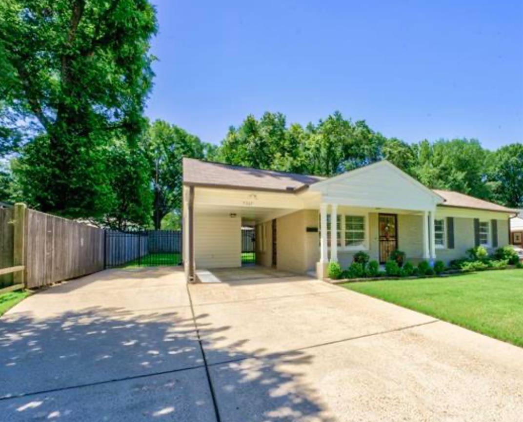 View of front of house featuring a carport, covered porch, and a front lawn