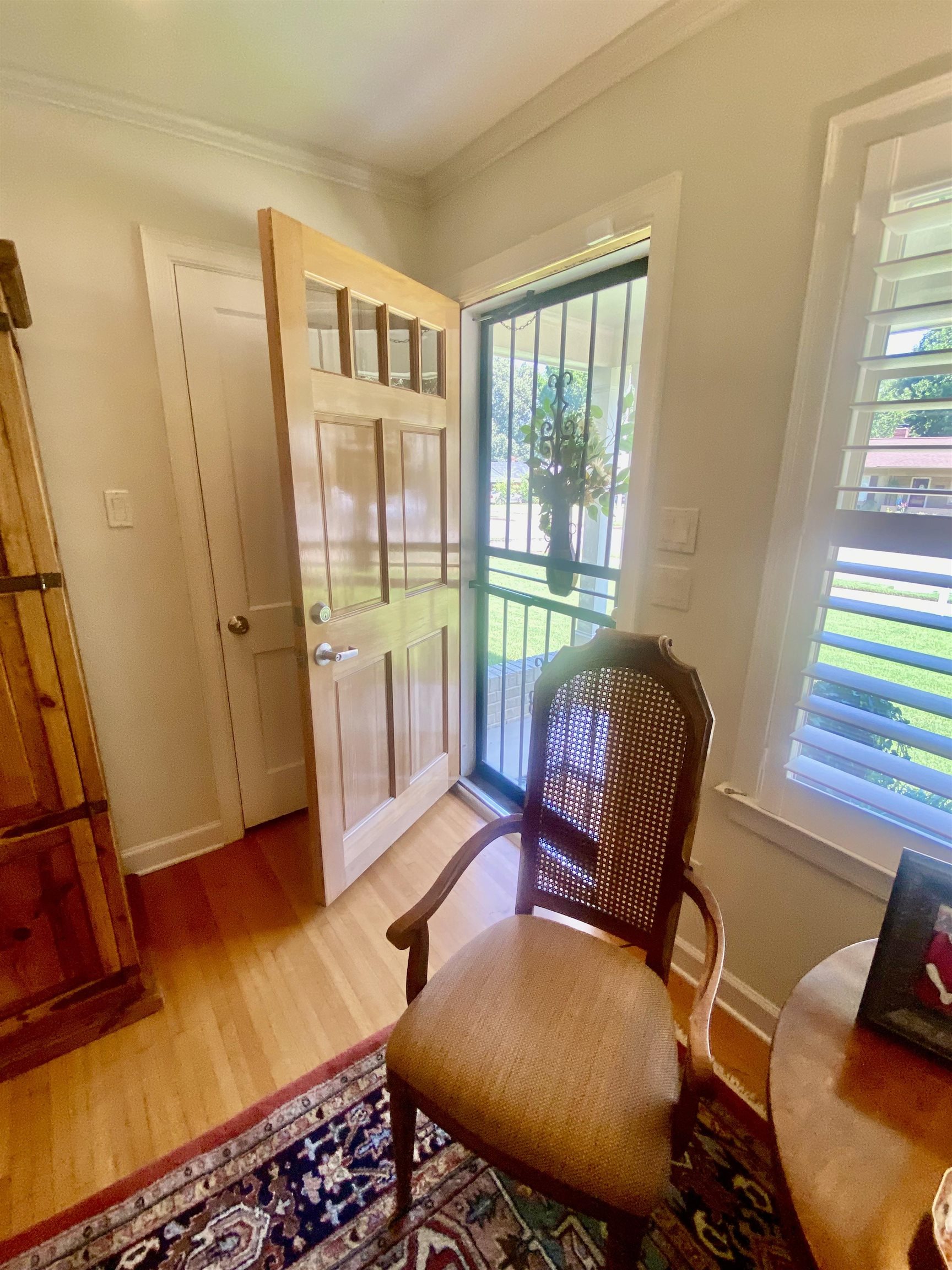 Living area with crown molding, wood-flooring, and a wealth of natural light