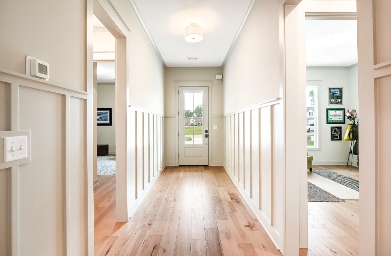 Doorway featuring crown molding and light wood-type flooring