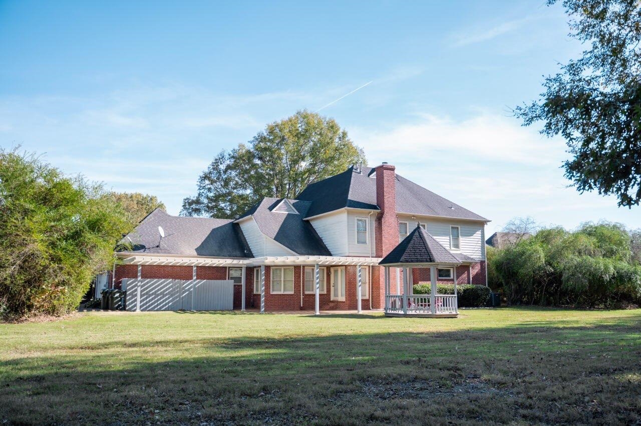 Back of house with a yard