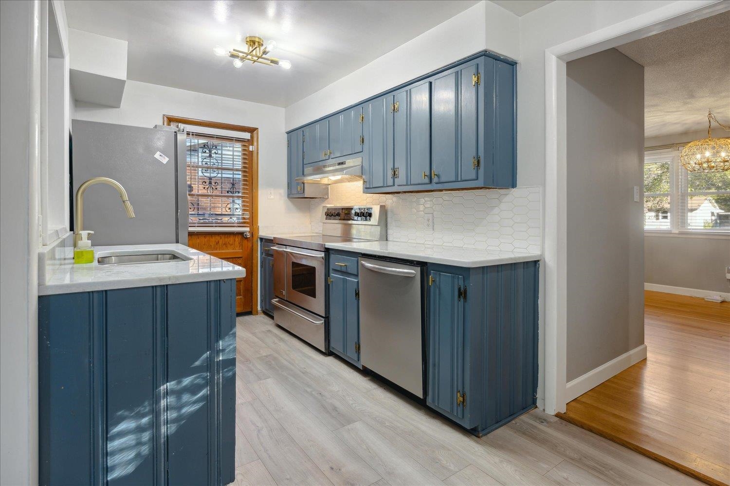 Kitchen featuring blue cabinetry, plenty of natural light, and stainless steel appliances