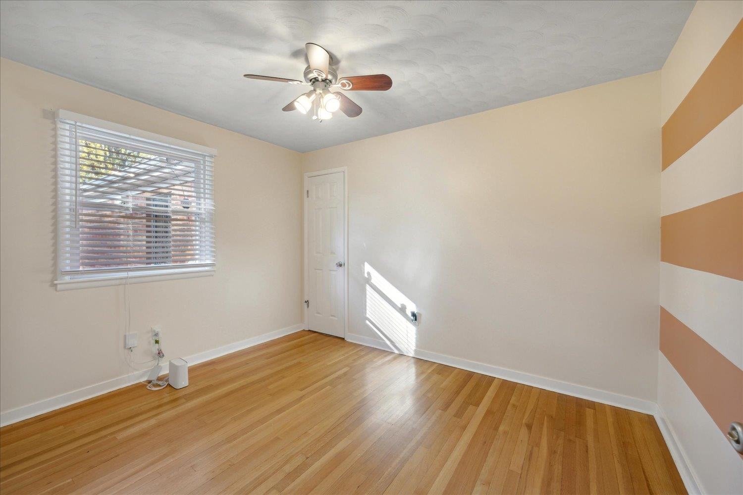 Unfurnished room with ceiling fan and light wood-type flooring