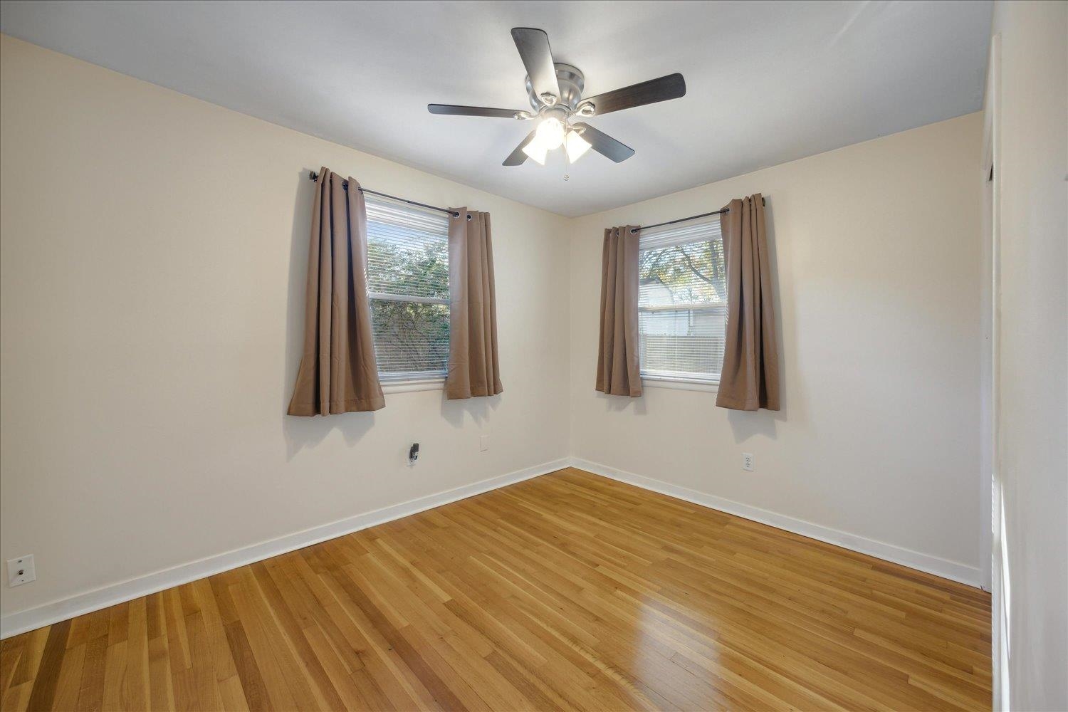 Unfurnished room featuring light wood-type flooring and ceiling fan